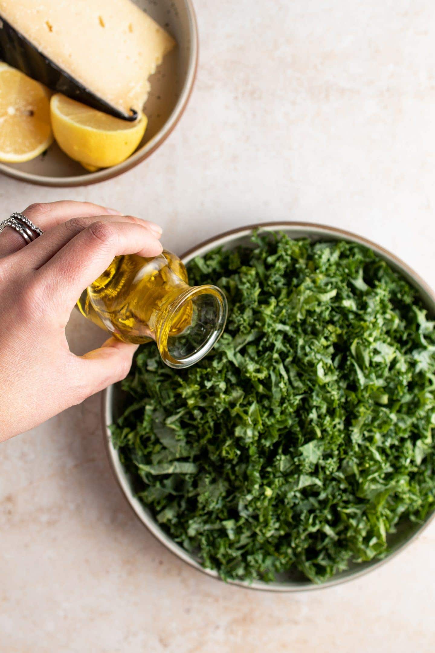 pouring olive oil over kale to massage it