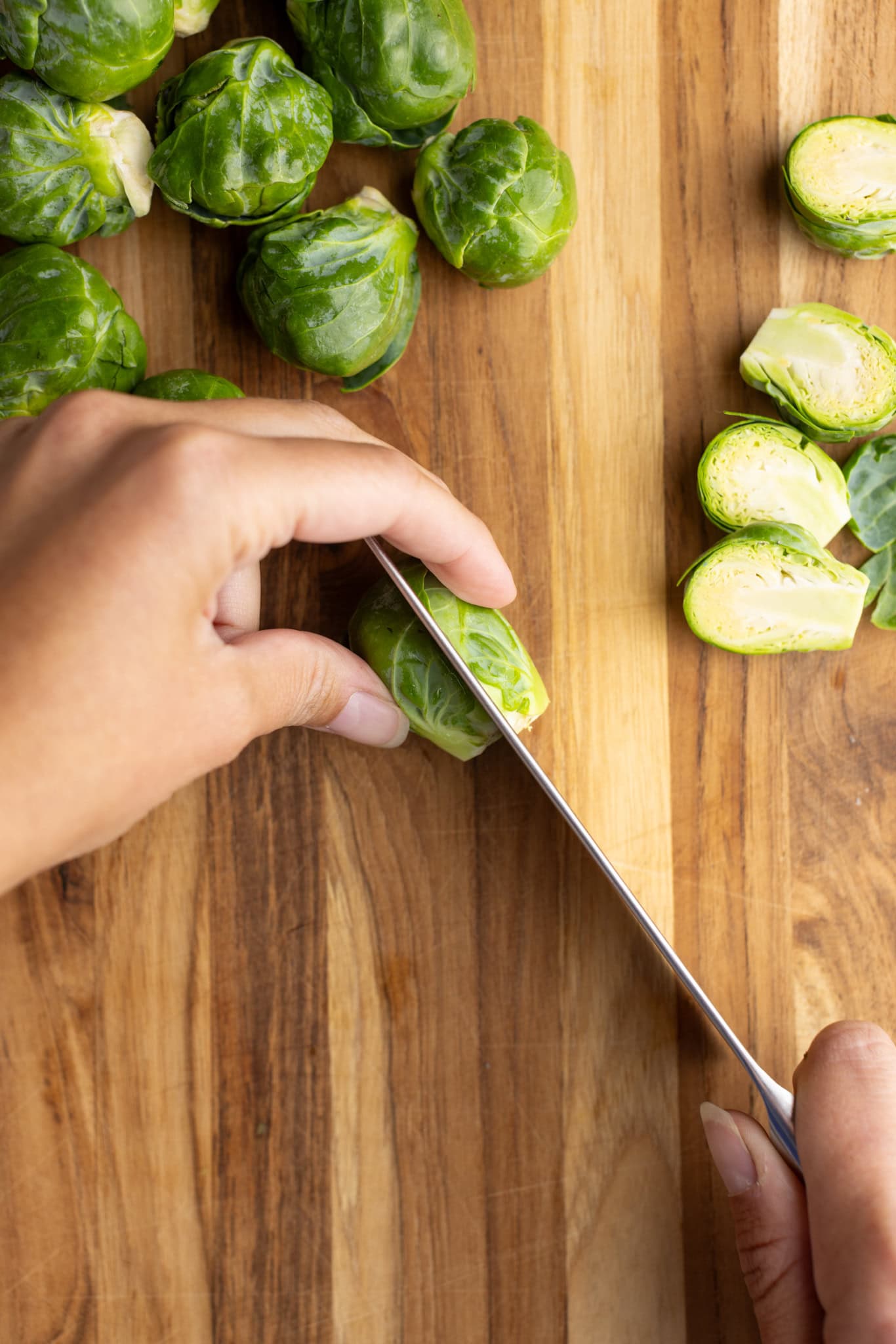 step by step: cutting the Brussel sprout lengthwise in half.