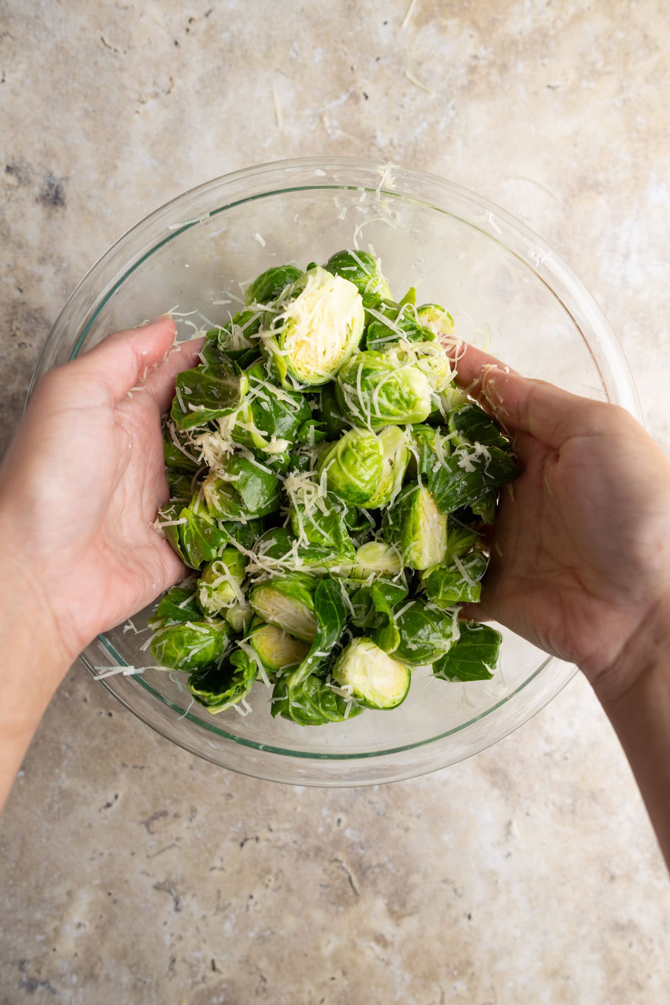 step by step: tossing the sprouts with hands for even coating.