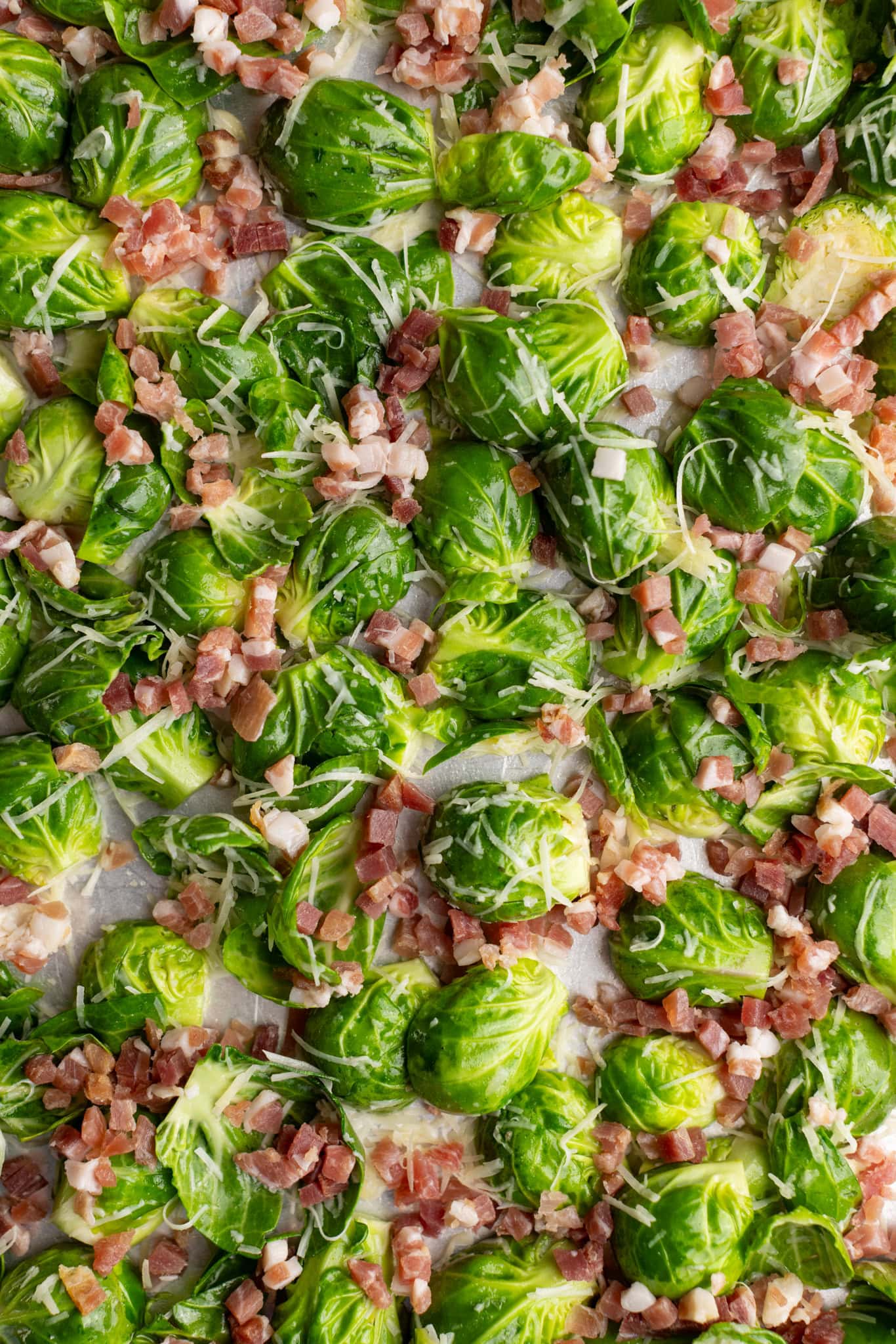 step by step: seasoned Brussels sprouts placed on a sheet pan with the cut side down.