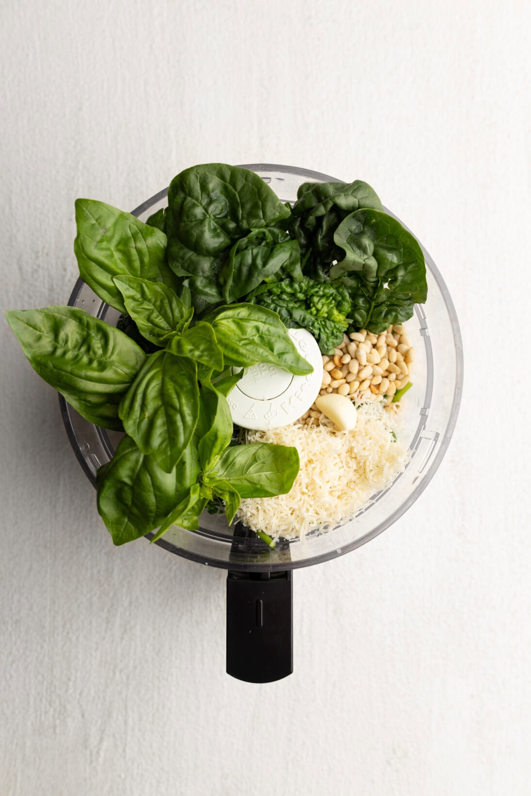 ingredients for spinach pesto ( basil, spinach, pine nuts, parm, and garlic)
