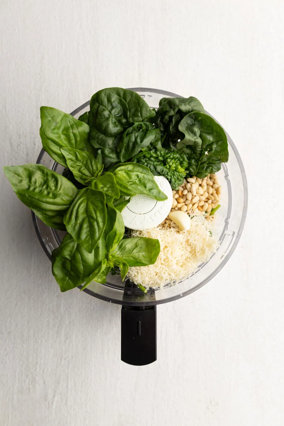 ingredients for spinach pesto ( basil, spinach, pine nuts, parm, and garlic)