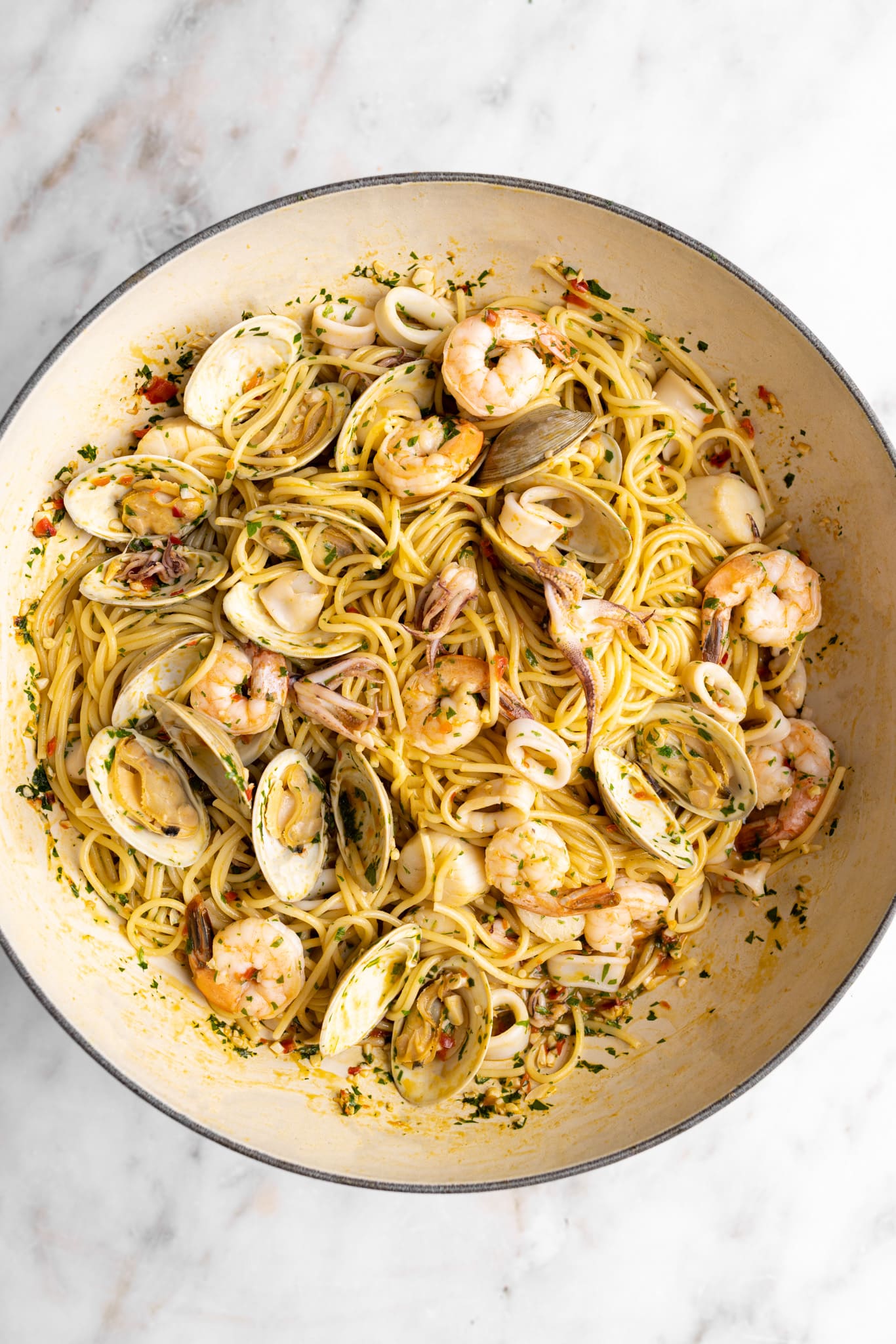 Seafood pasta in a wide braiser (clams, squid, squid, and shrimp over linguini)