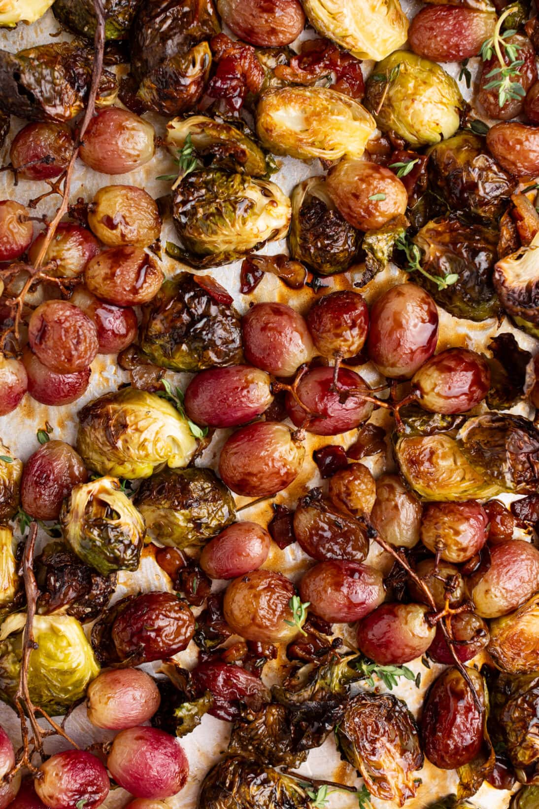 roasted grapes, brussels sprouts and rendered bacon on a sheet tray.