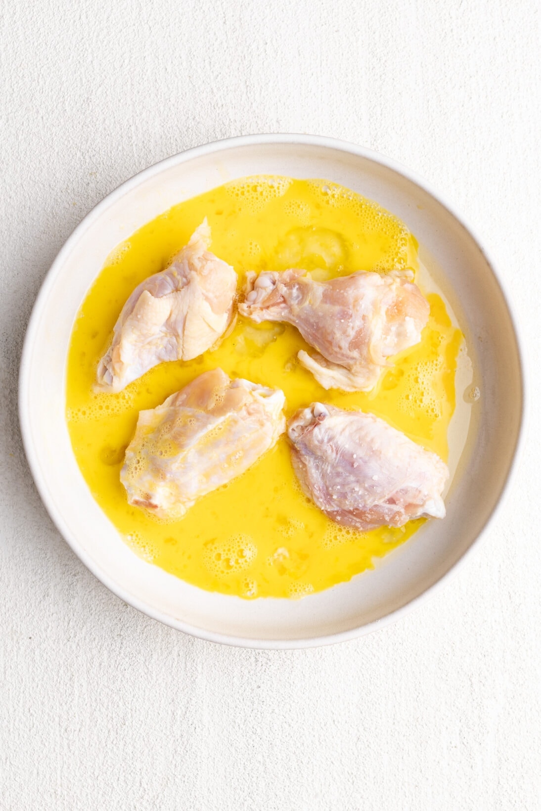 raw wings getting coated in egg