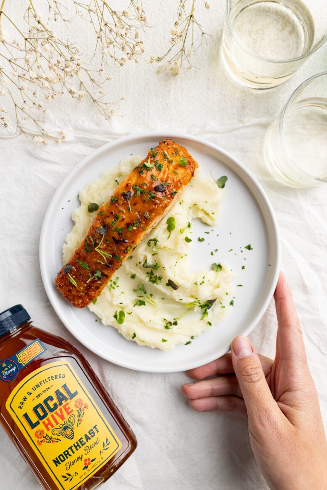 honey mustard salmon over a bed of creamy mashed potatoes topped with parsley and micro greens. 