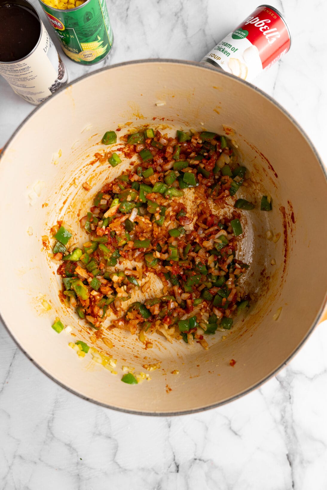 cooking the onions and bell peppers in tomato paste