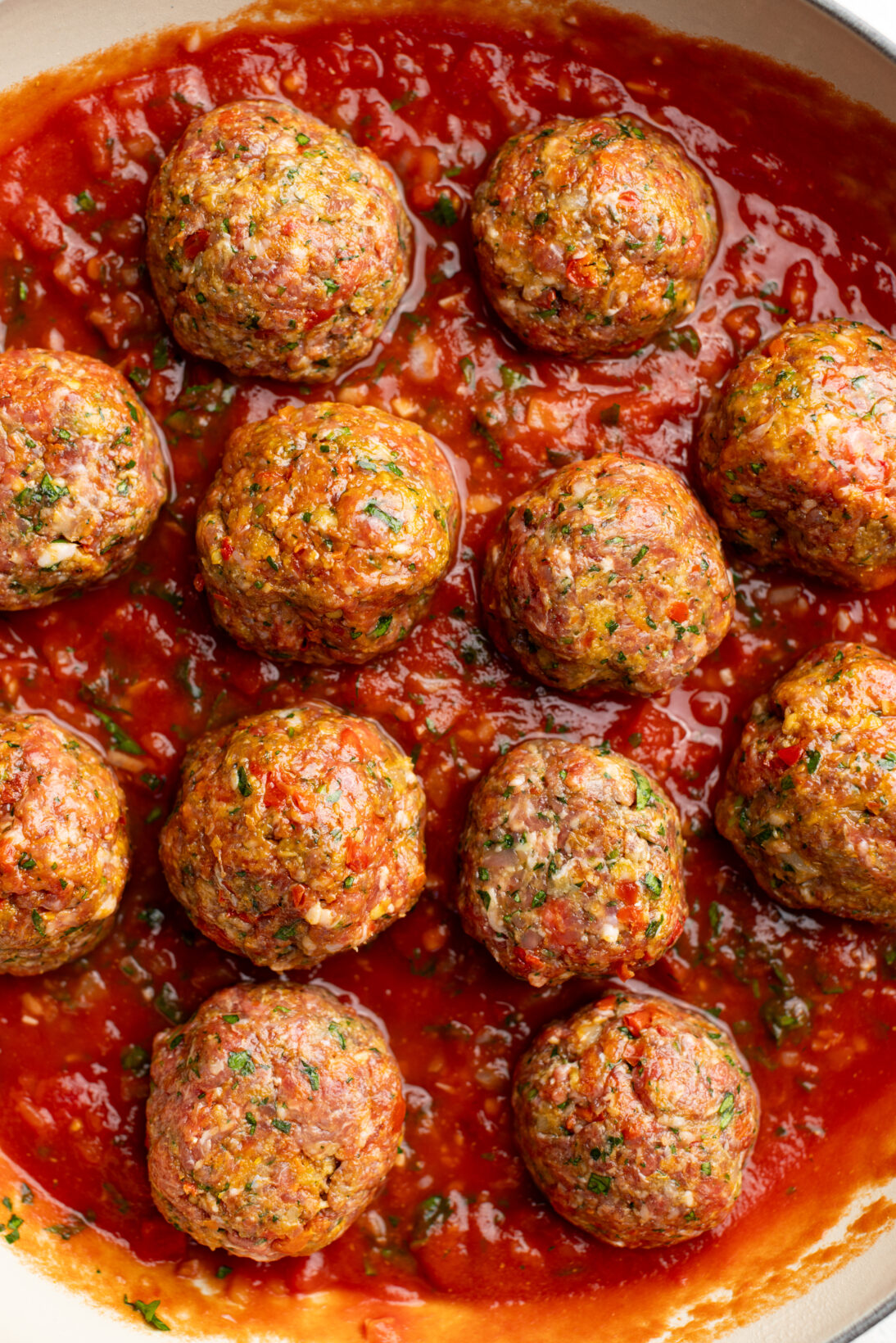 meatballs placed in the simmering sauce before going into the oven