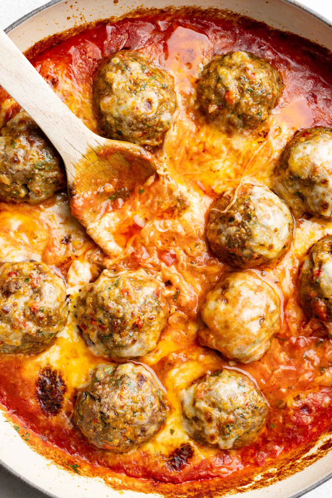 Calabrian spicy meatballs after being baked toped with cheese
