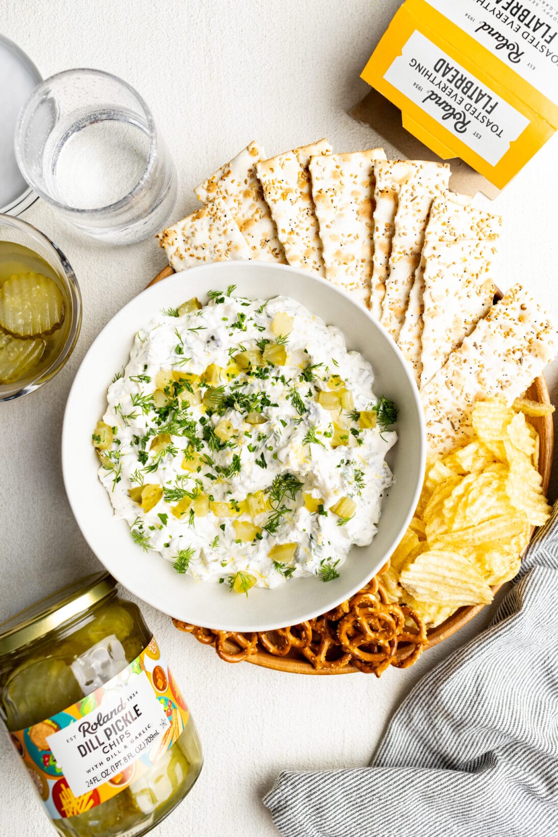 plate of dill pickle dip, everything flatbread crackers, chips and pretzels. 