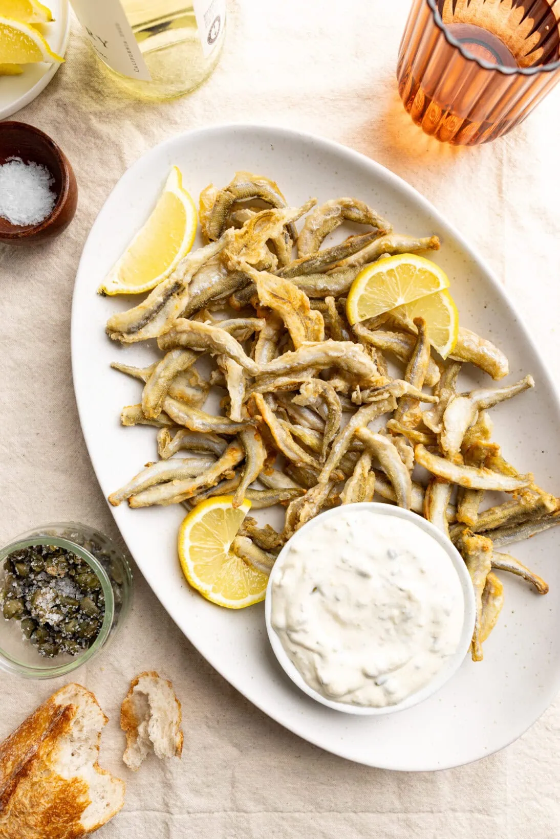 large family sized plate of crispy fried smelt with fresh lemon and a lemon caper aioli. 