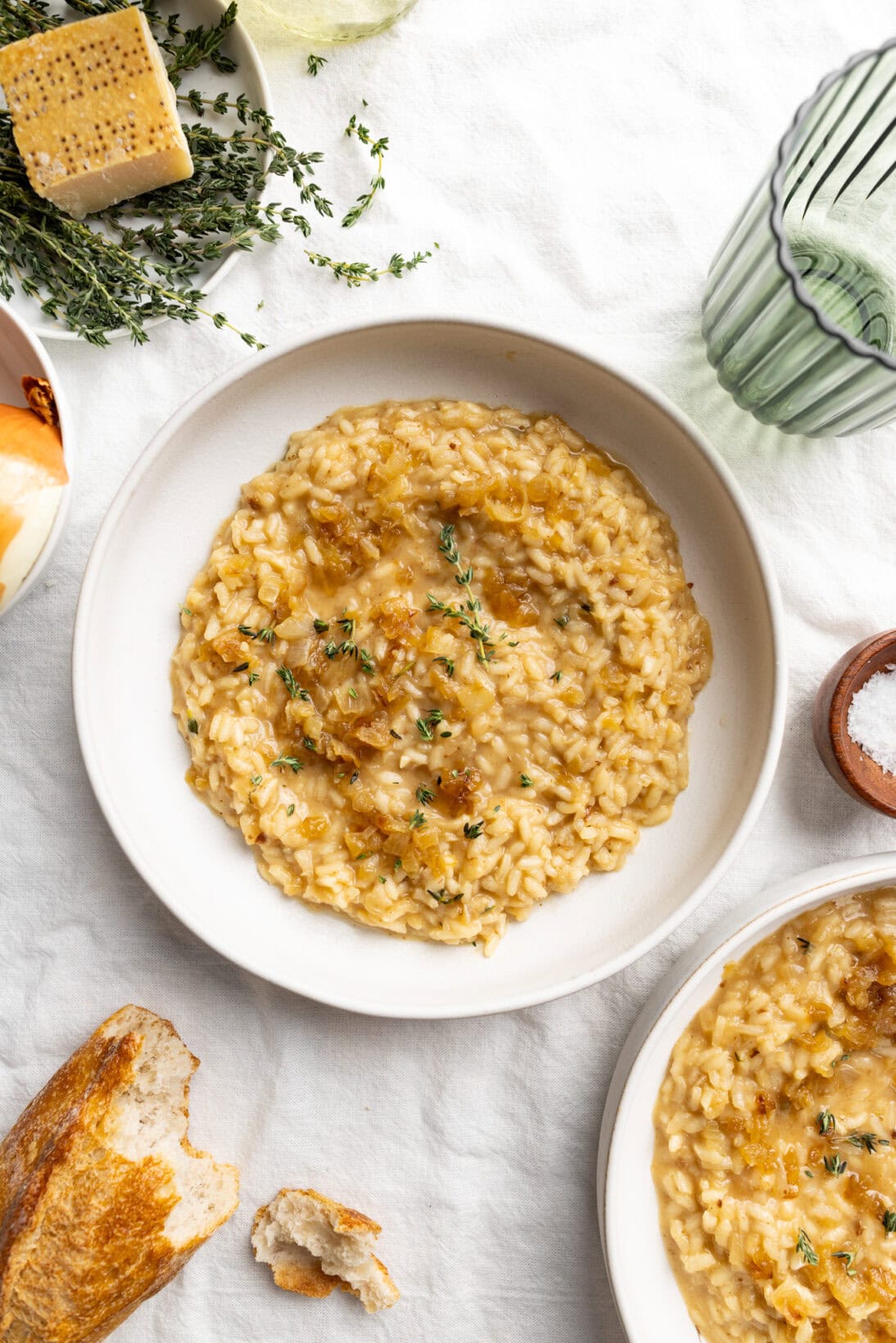 bowl of french onion risotto topped with caramelized onions and thyme.