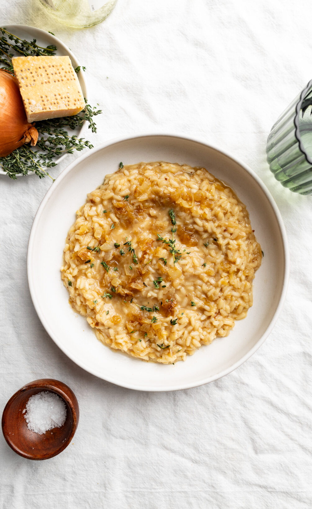 bowl of french onion risotto topped with caramelized onions and thyme.