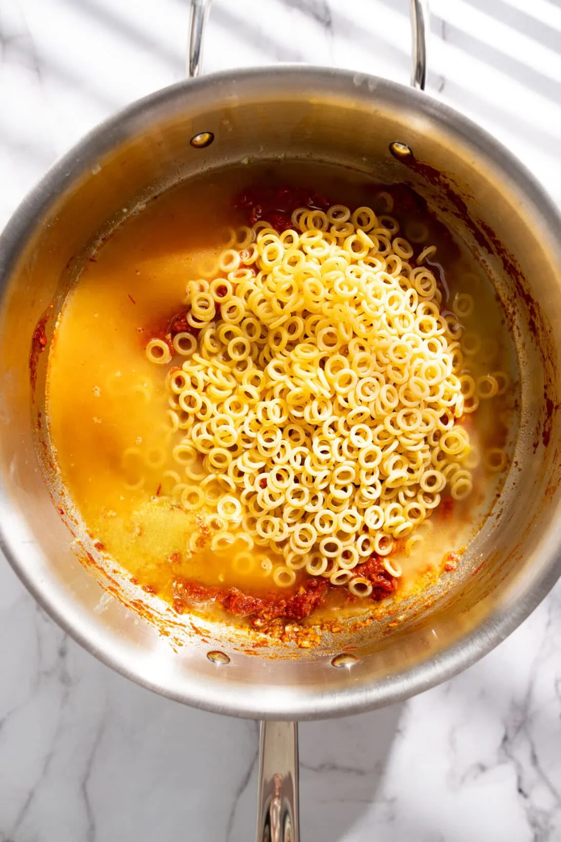 added the pasta and broth to the pan