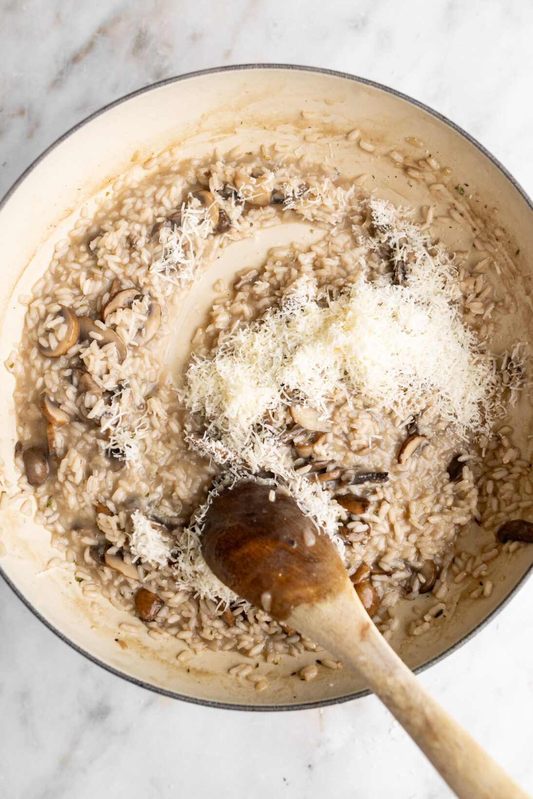 Making mushroom risotto: mixing in the parmesan cheese