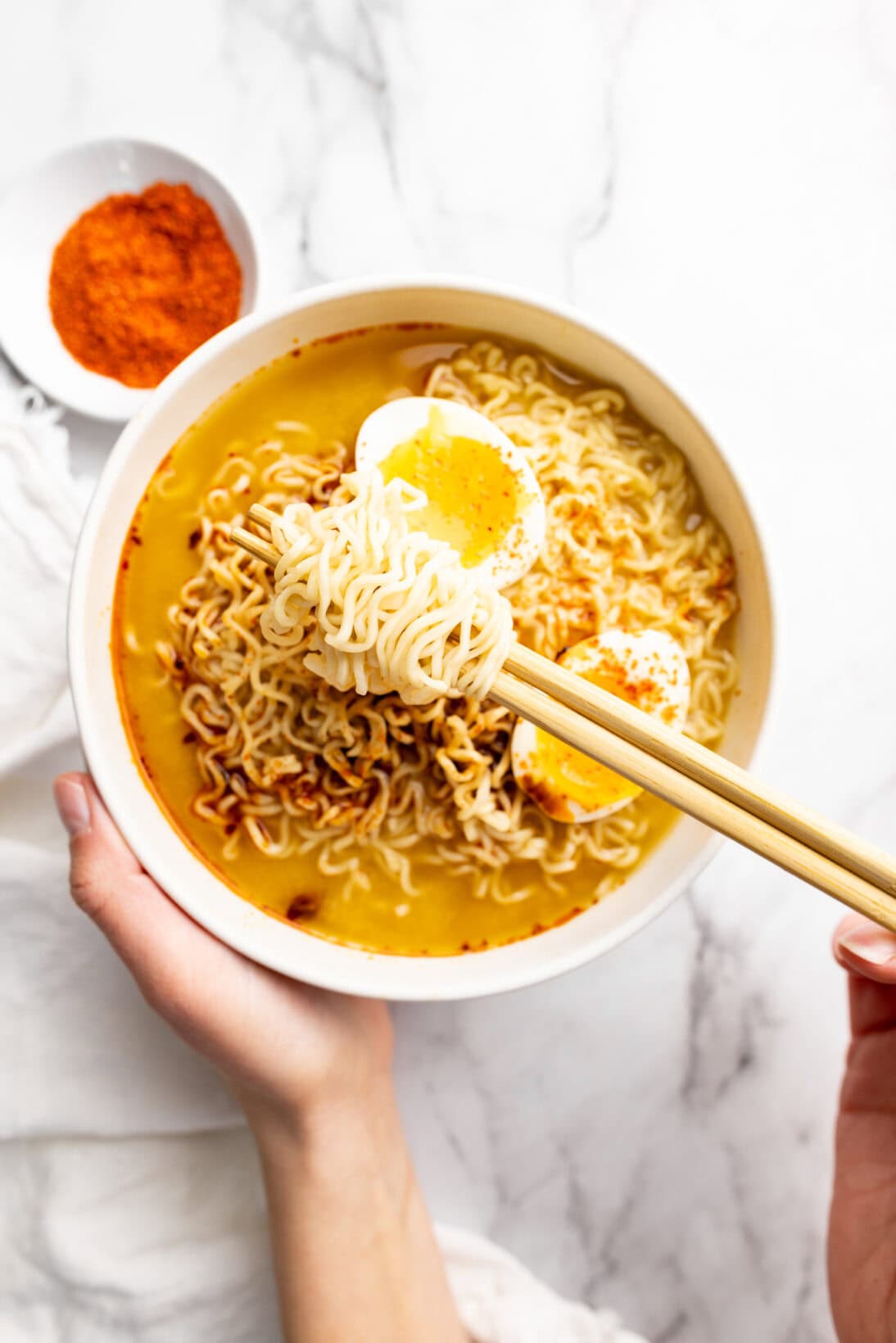 pulling noodles with chopsticks from the ramen bowl