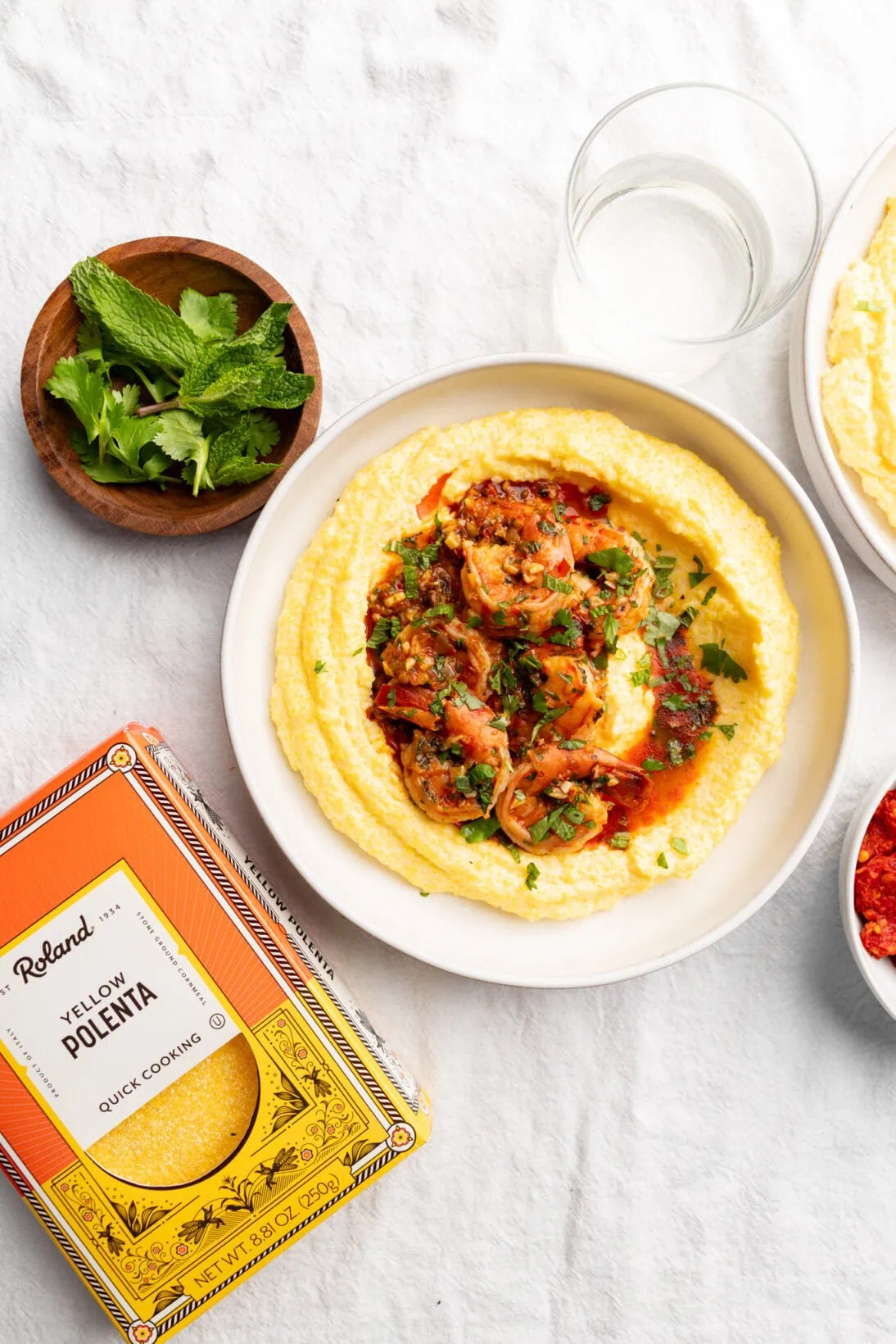a bowl of spicy harissa shrimp over creamy polenta