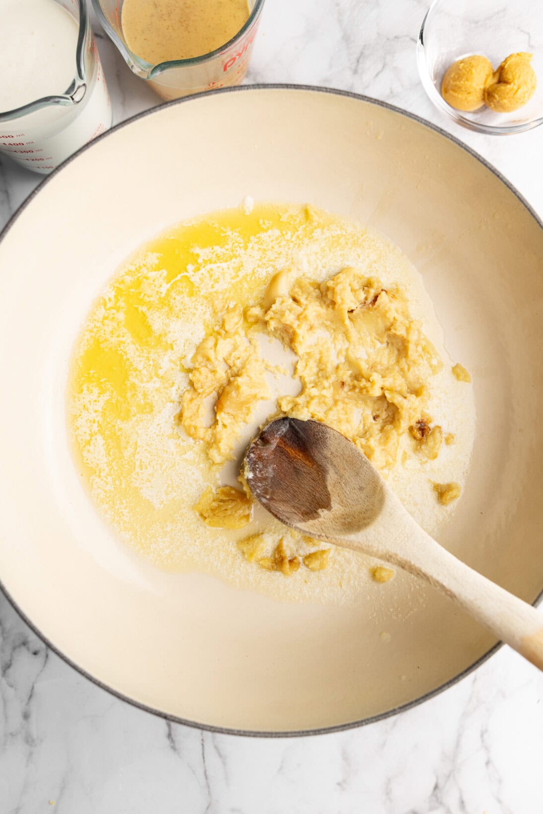 step my step process: smashing the roasted garlic into the butter.