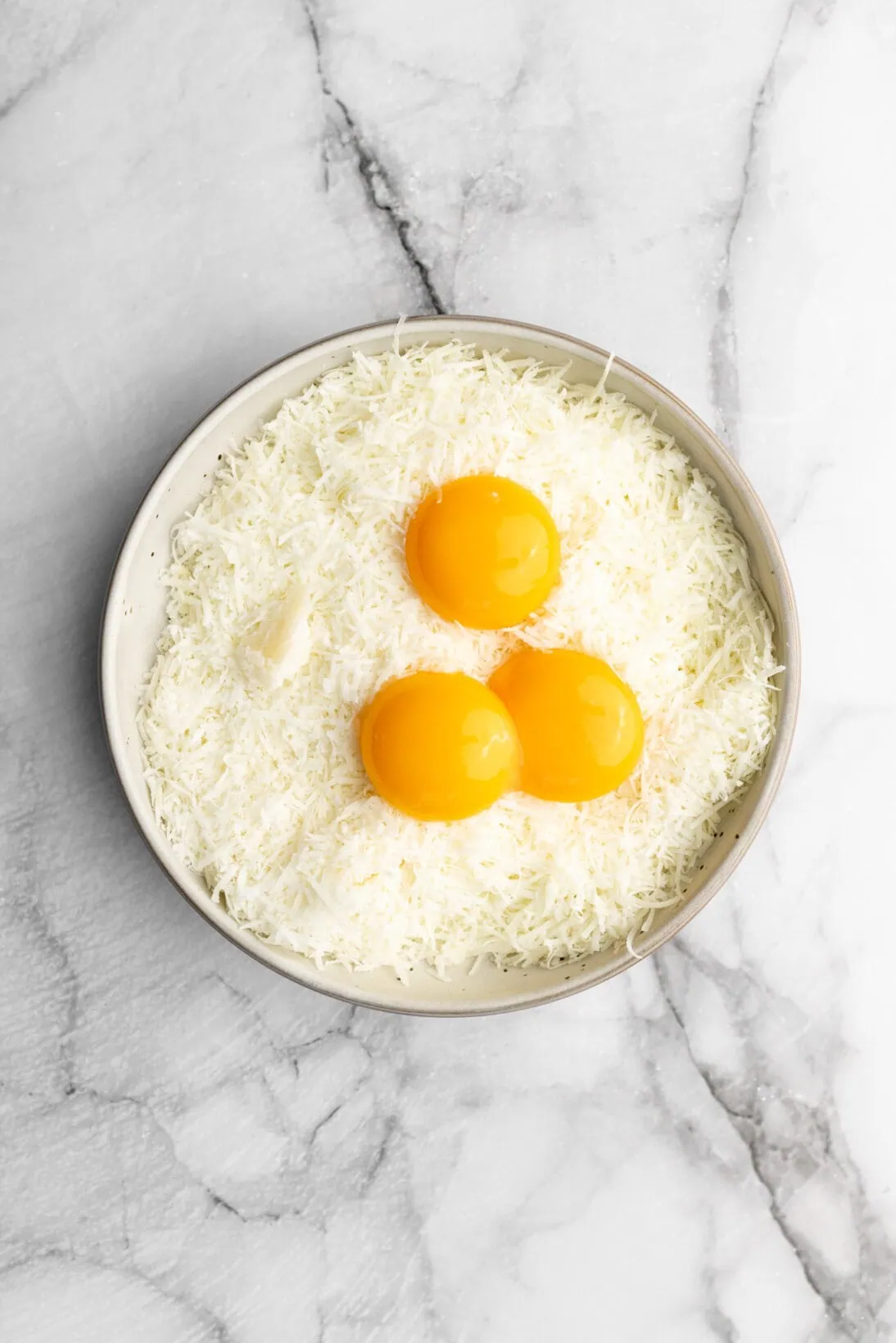 eggs and grated pecorino romano cheese in a bowl