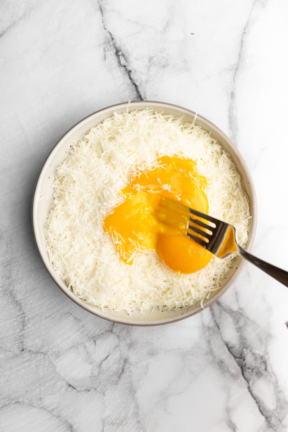 combining the eggs and grated pecorino romano cheese