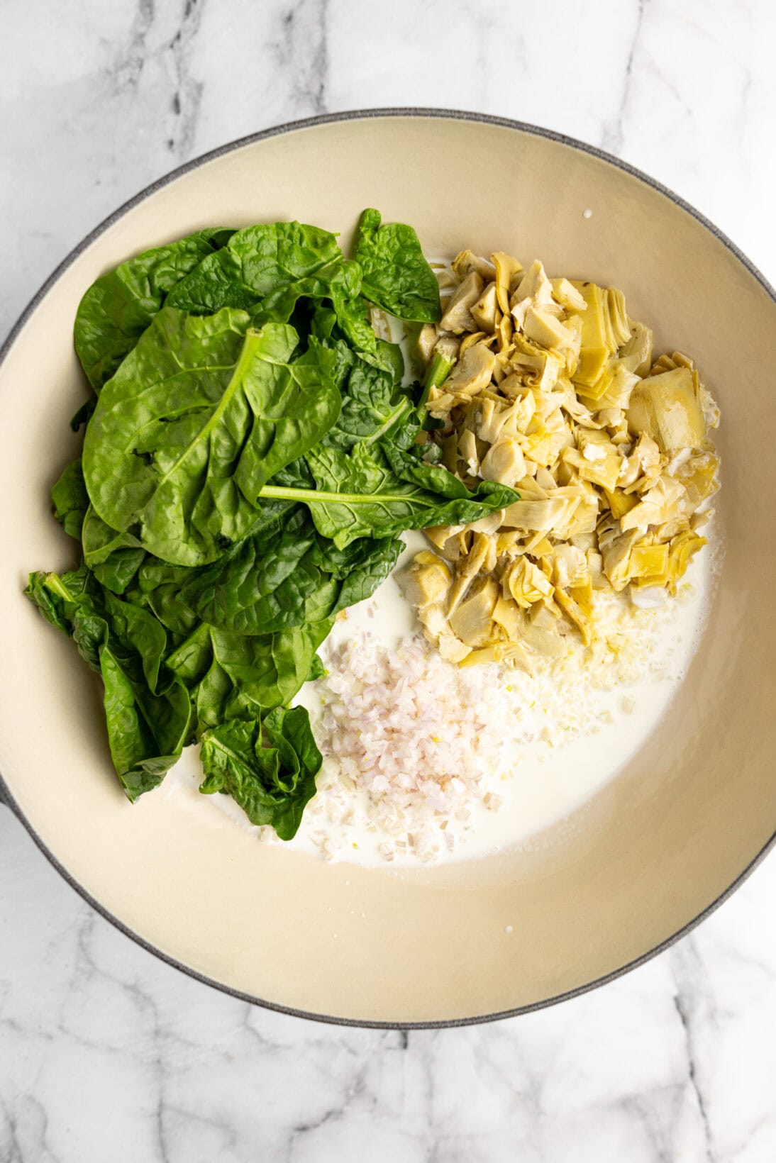 pot with heavy cream, shallot, garlic, artichokes, and spinach .