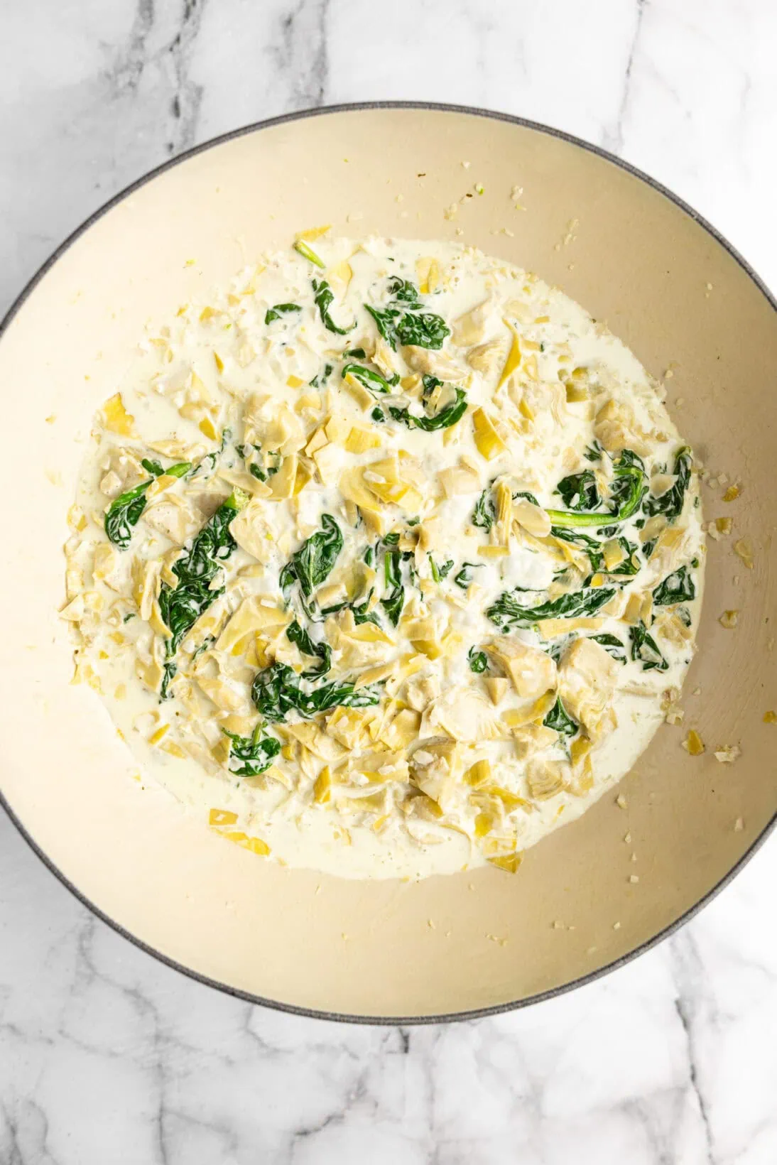simmered pot with heavy cream, shallot, garlic, artichokes, and spinach .
