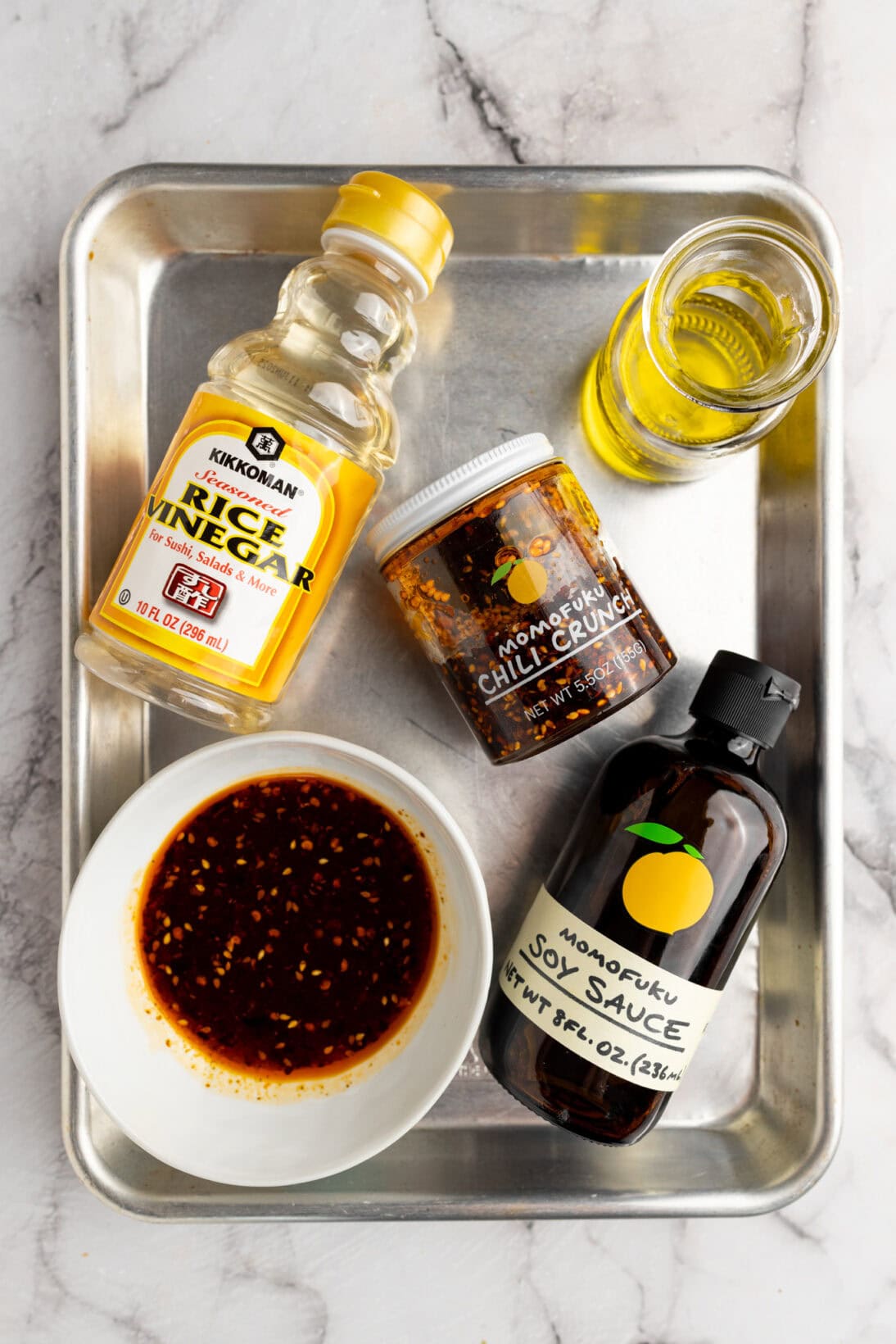 the ingredients needed to make the dressing (oil, rice vinegar, chili crunch, and soy sauce)