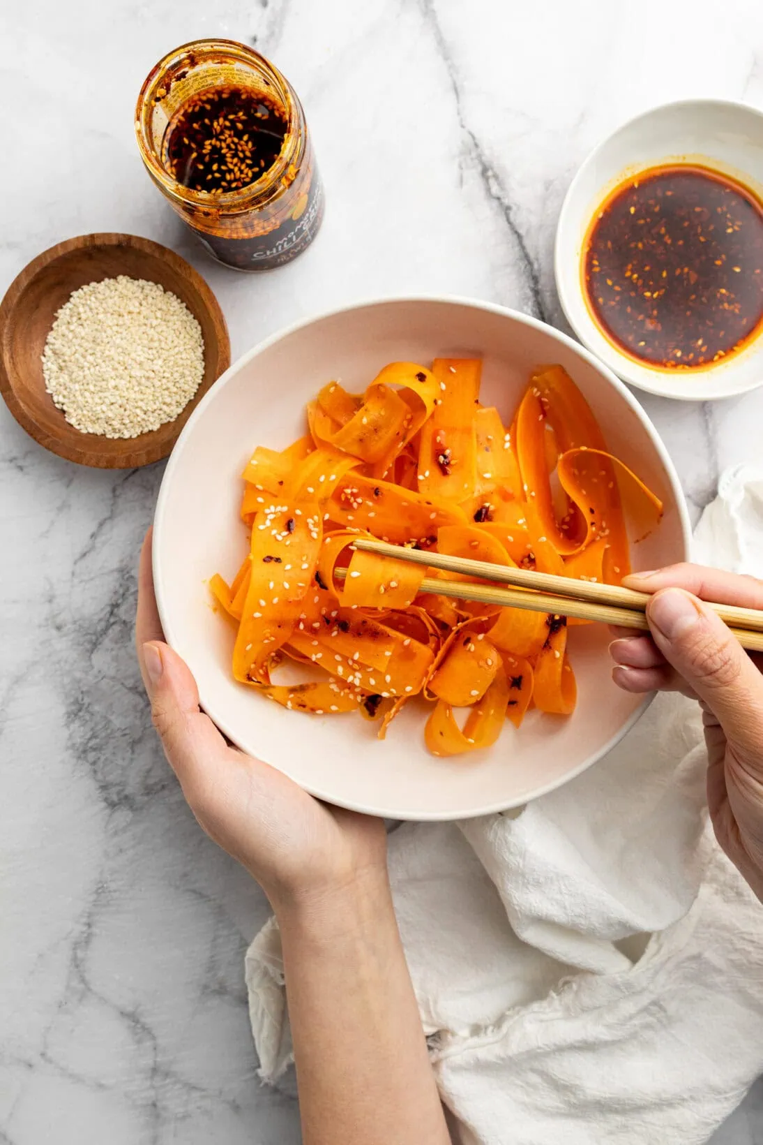 eating dressed raw carrot salad out of a bowl.