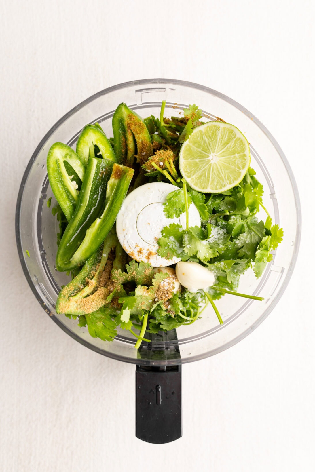 food processor with the ingredients for zhoug