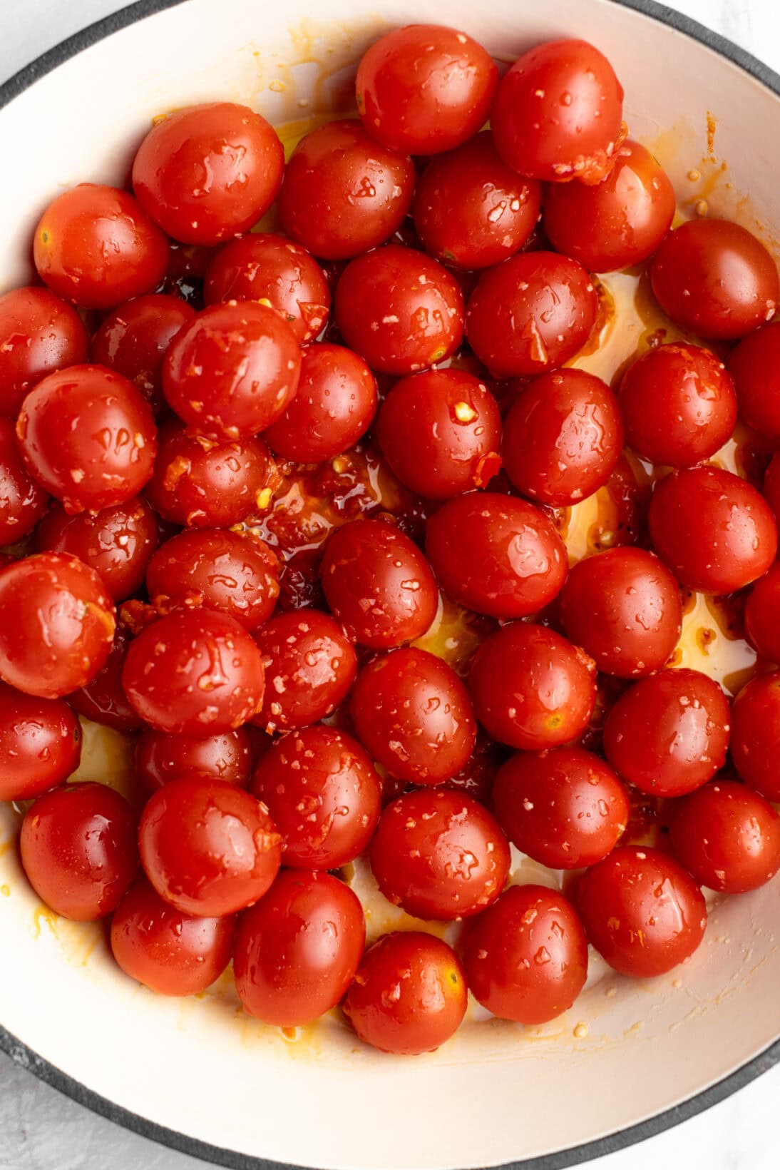 up close raw tomatoes coated in EVOO and Calabrian chilis