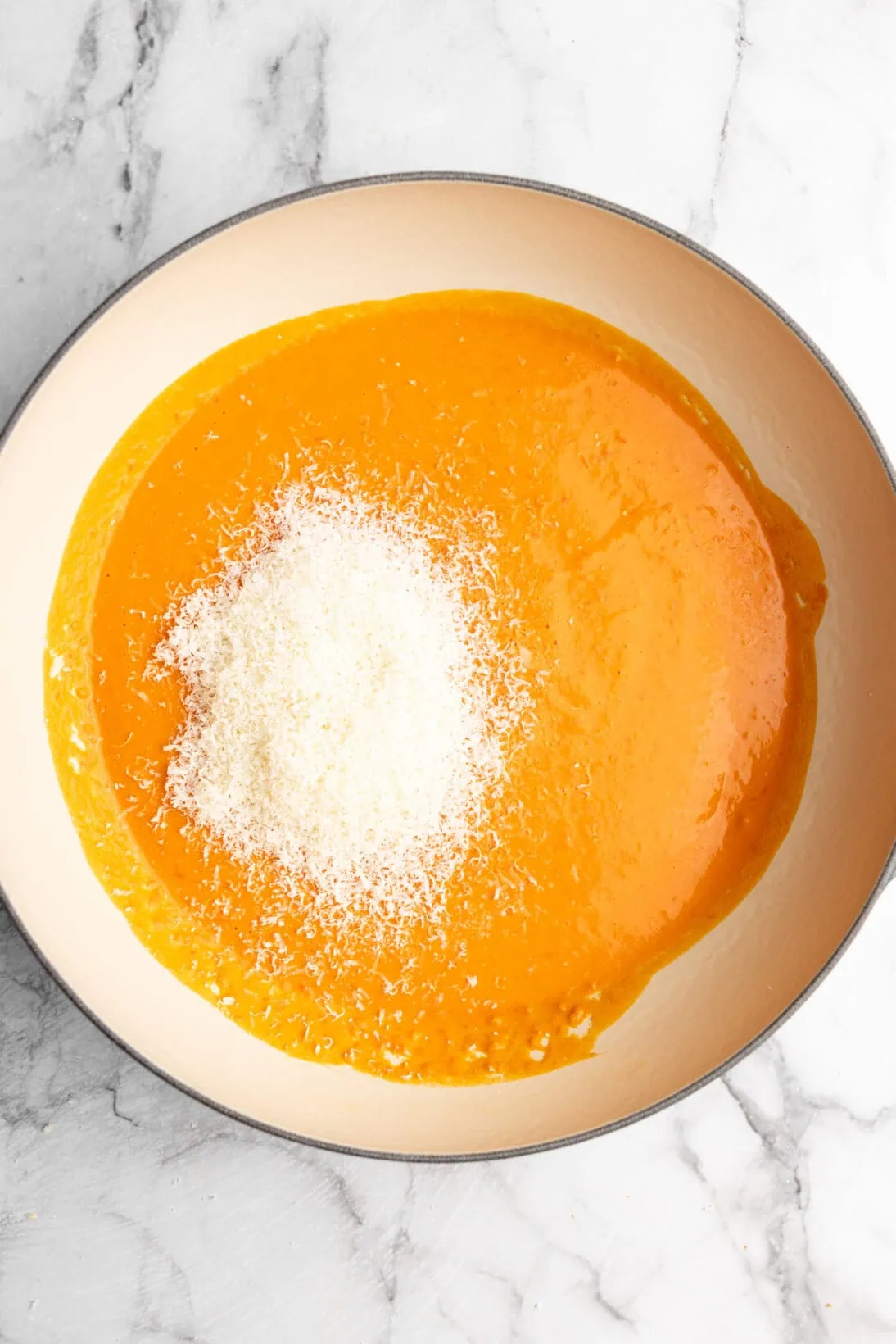 sauce added to a braiser with Parmesan cheese