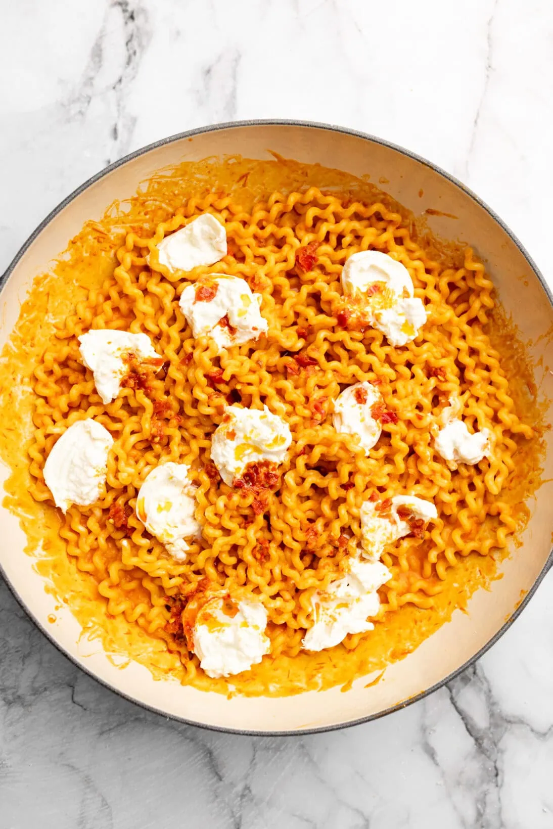 finished roasted tomato pasta sauce on pasta topped with creamy burrata and more Calabrian chilis 