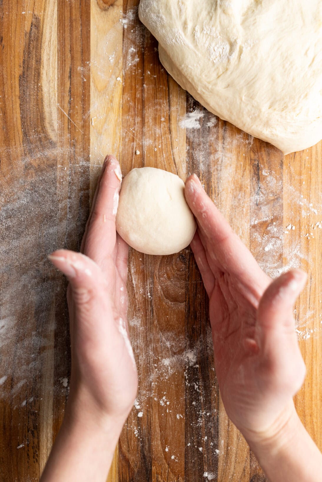 smoothing out the dough ball.
