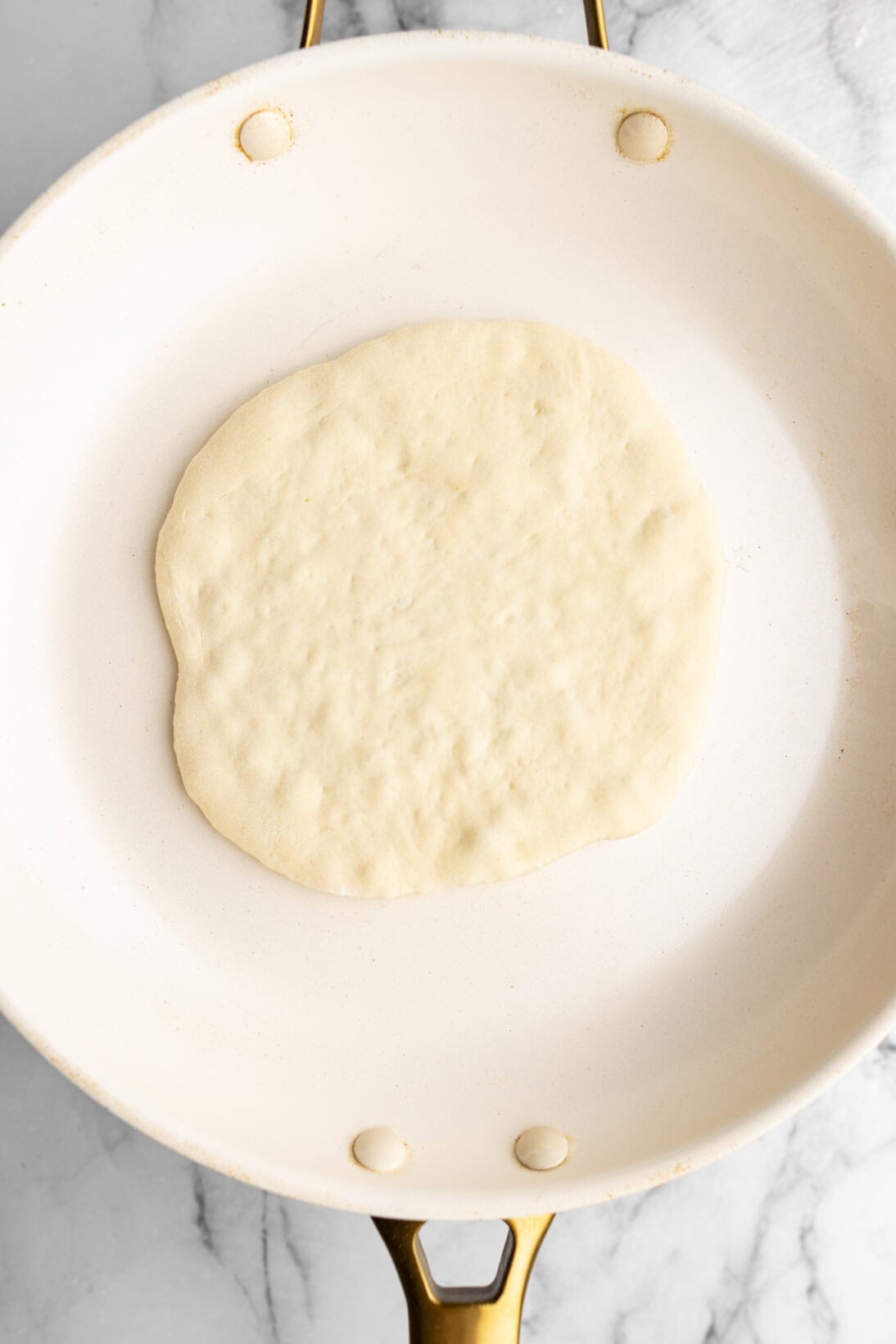 placed the raw homemade pita bread in a hot pan