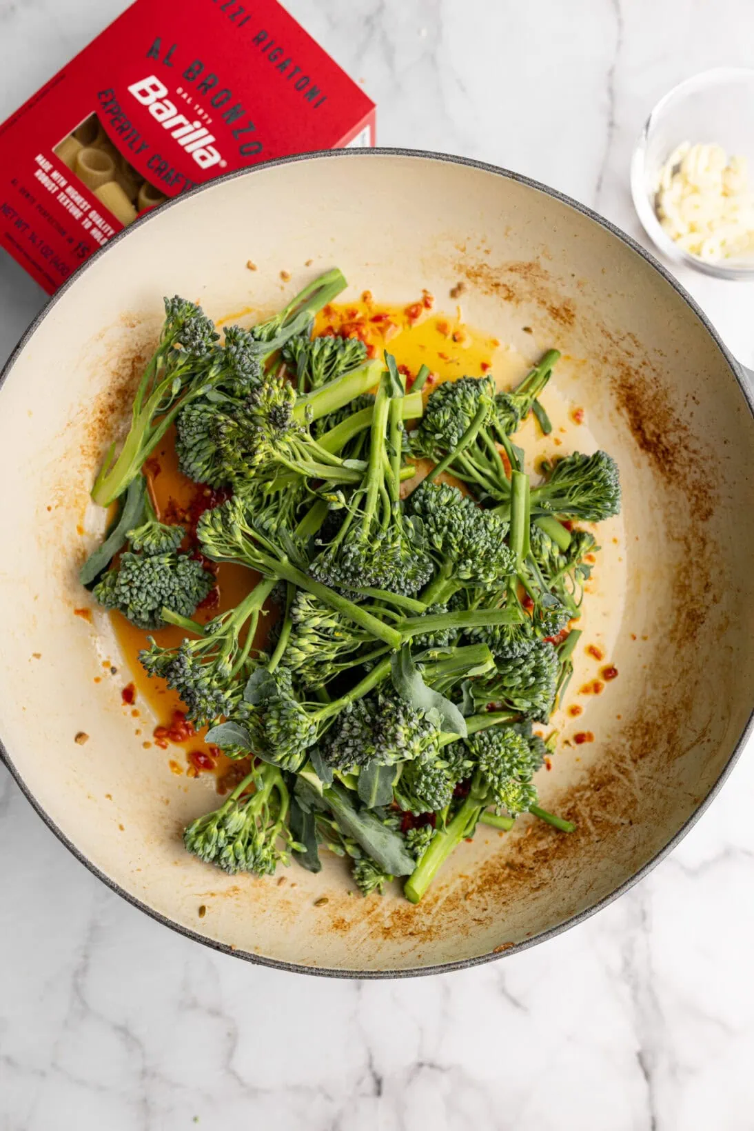 broccolini sautéing in Calabrian chili and garlic oil