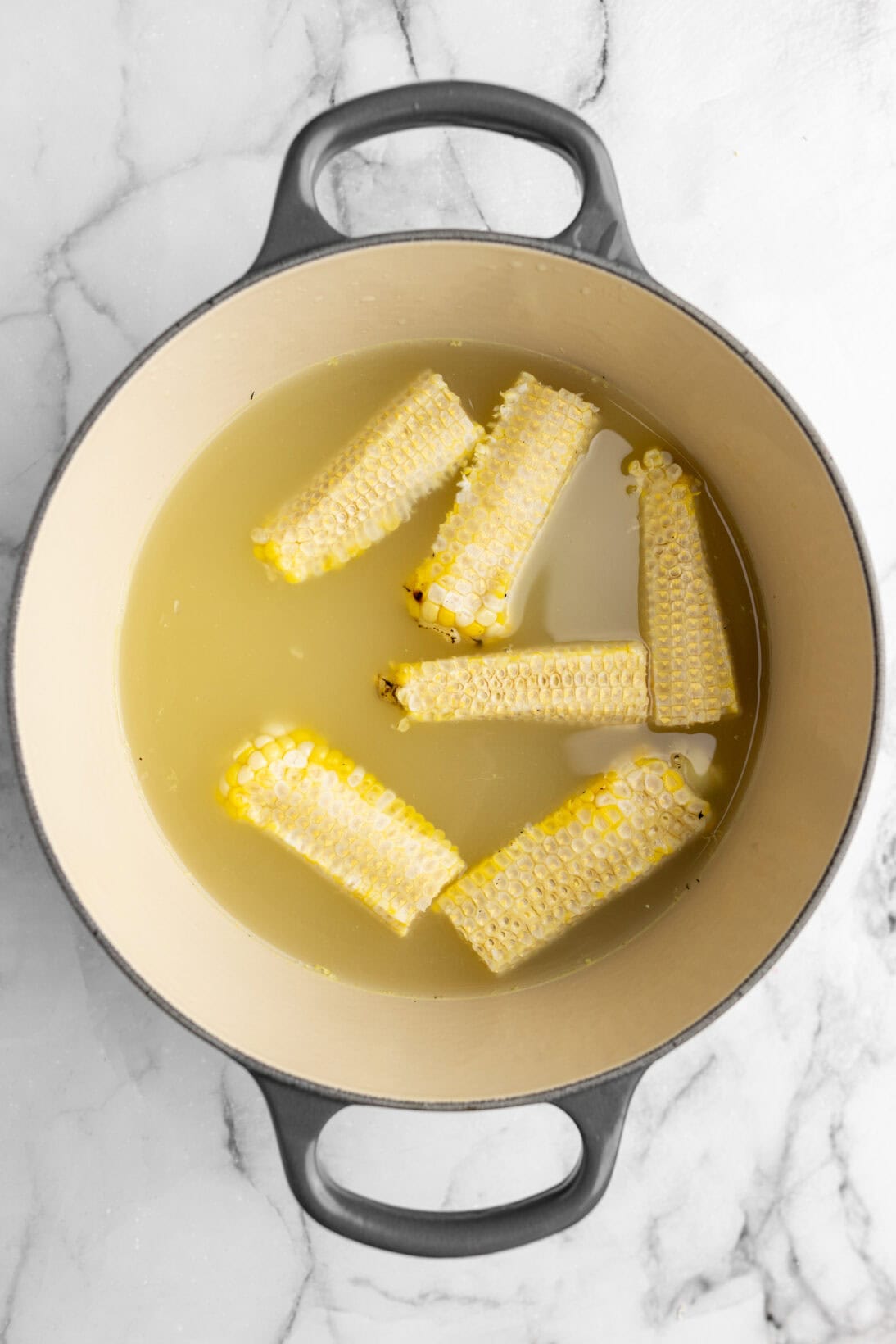 corn cobs simmering in the chicken broth