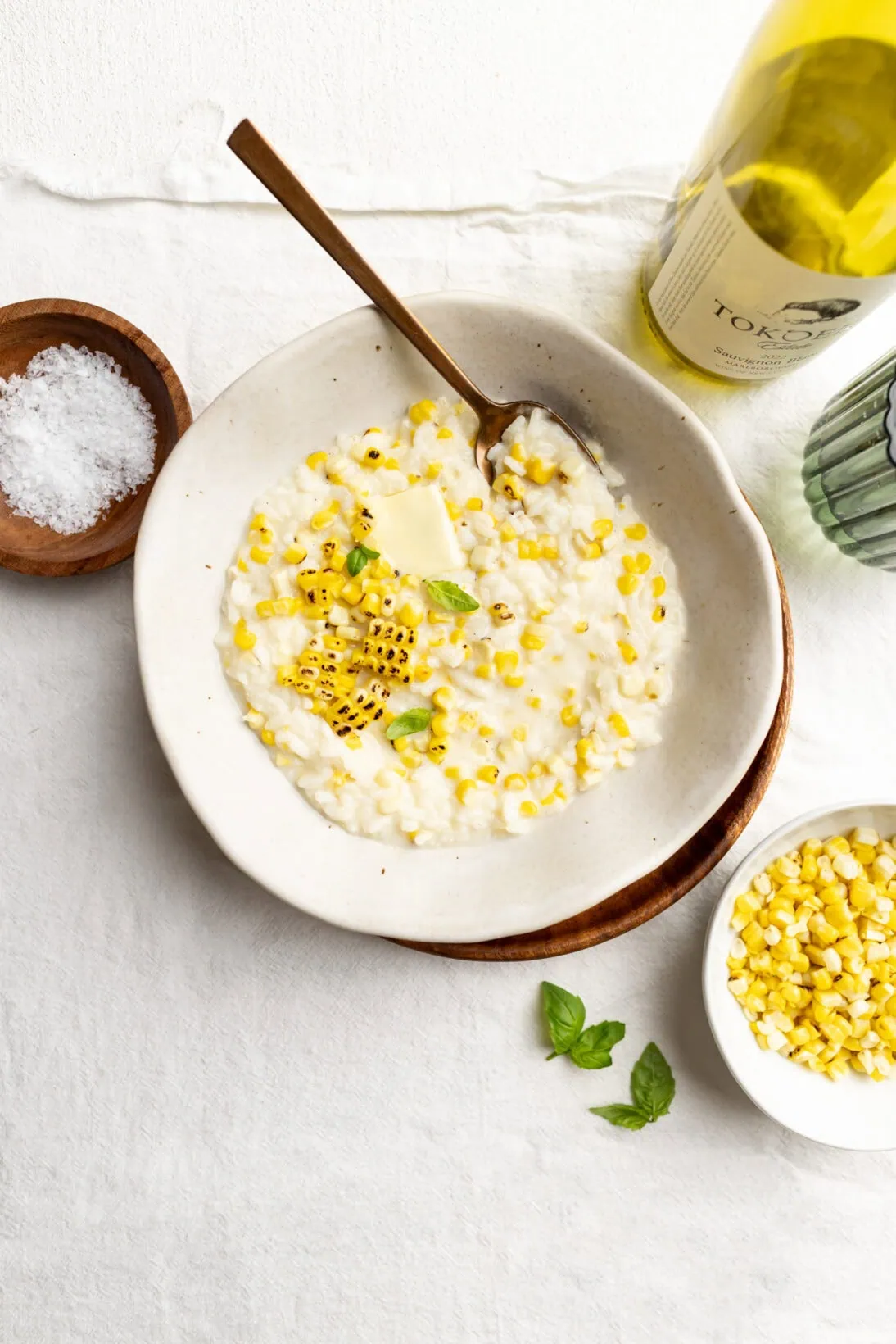 a bowl of sweet corn risotto topped with extra charred grilled corn and a knob of butter.