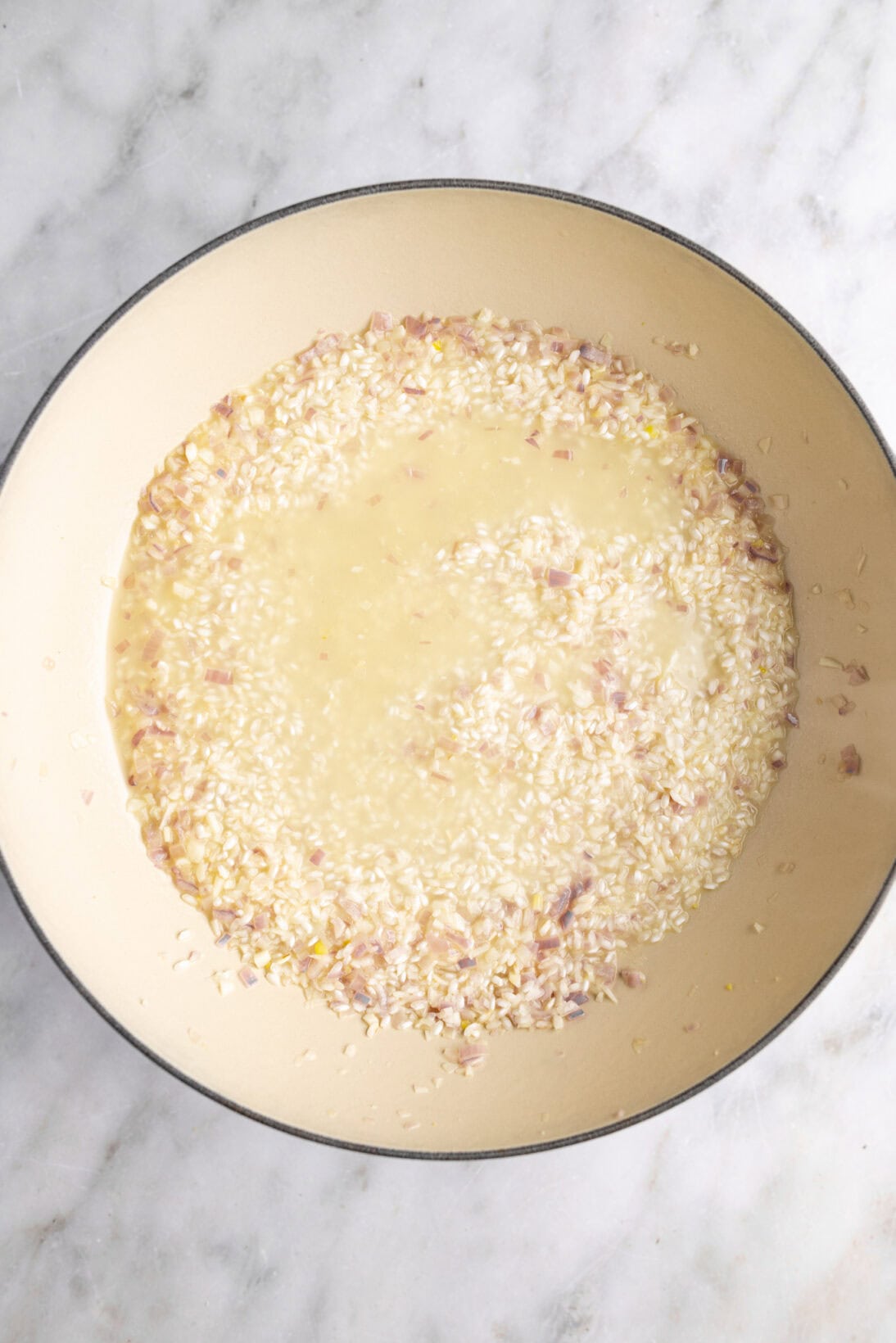 making risotto: adding broth to the risotto.