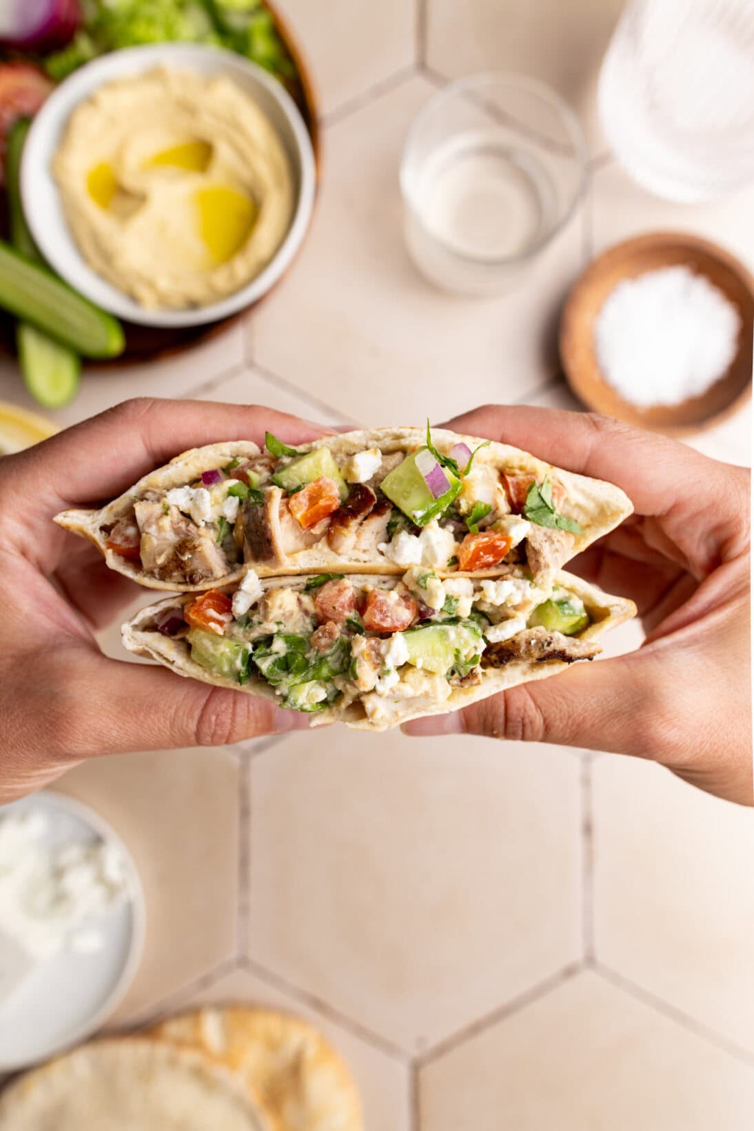 cross cut of an open pita stuffed with hummus chicken salad.