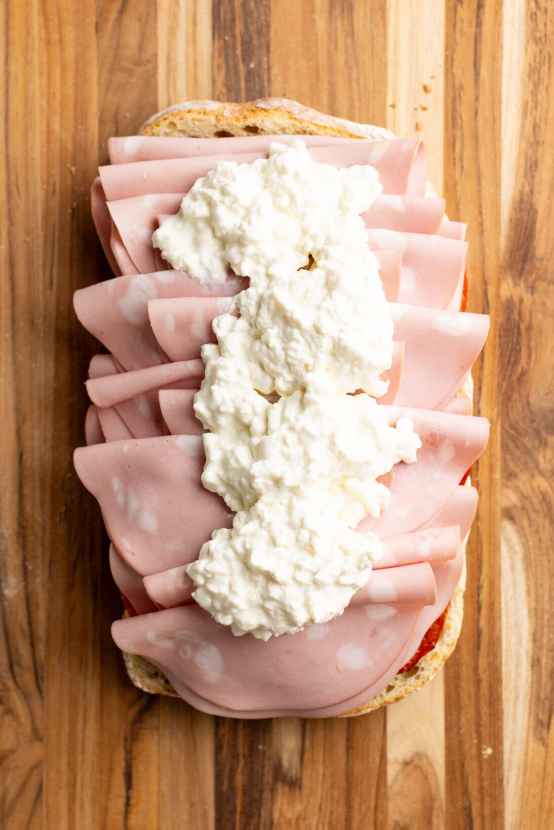 ciabatta loaf with layers of mortadella and stracciatella cheese.