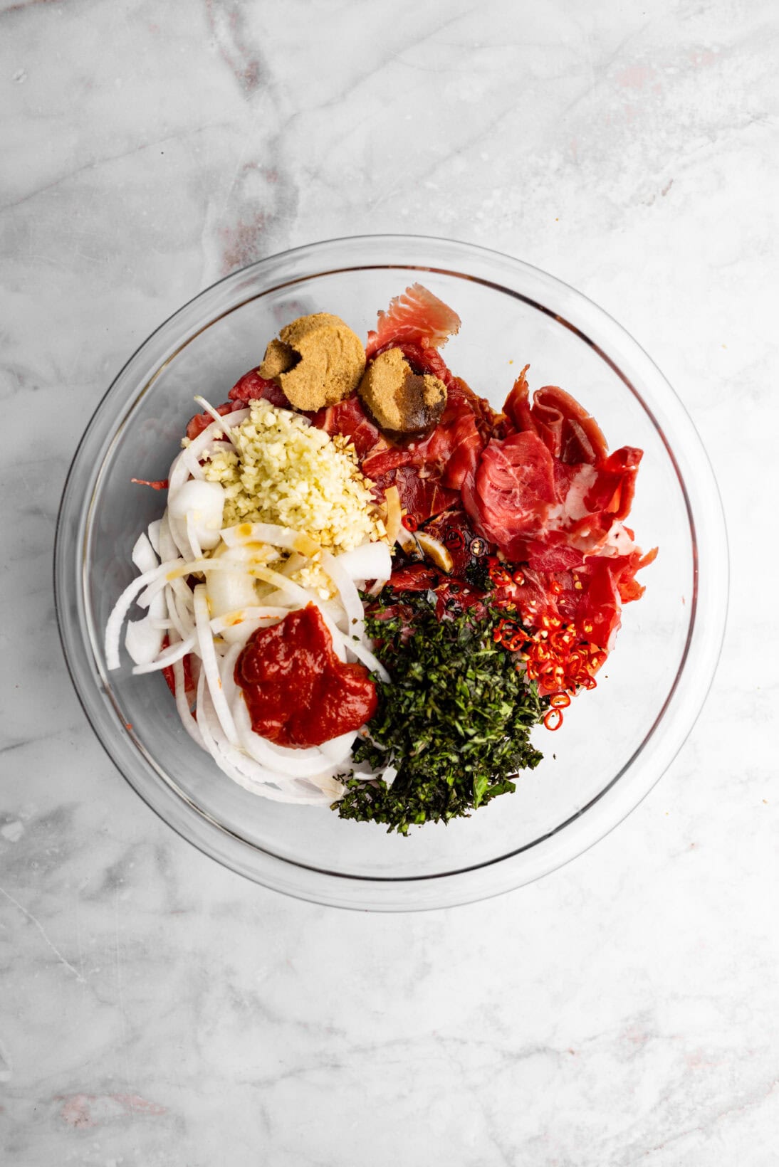 Beef in a bowl with all the marinade ingredients.