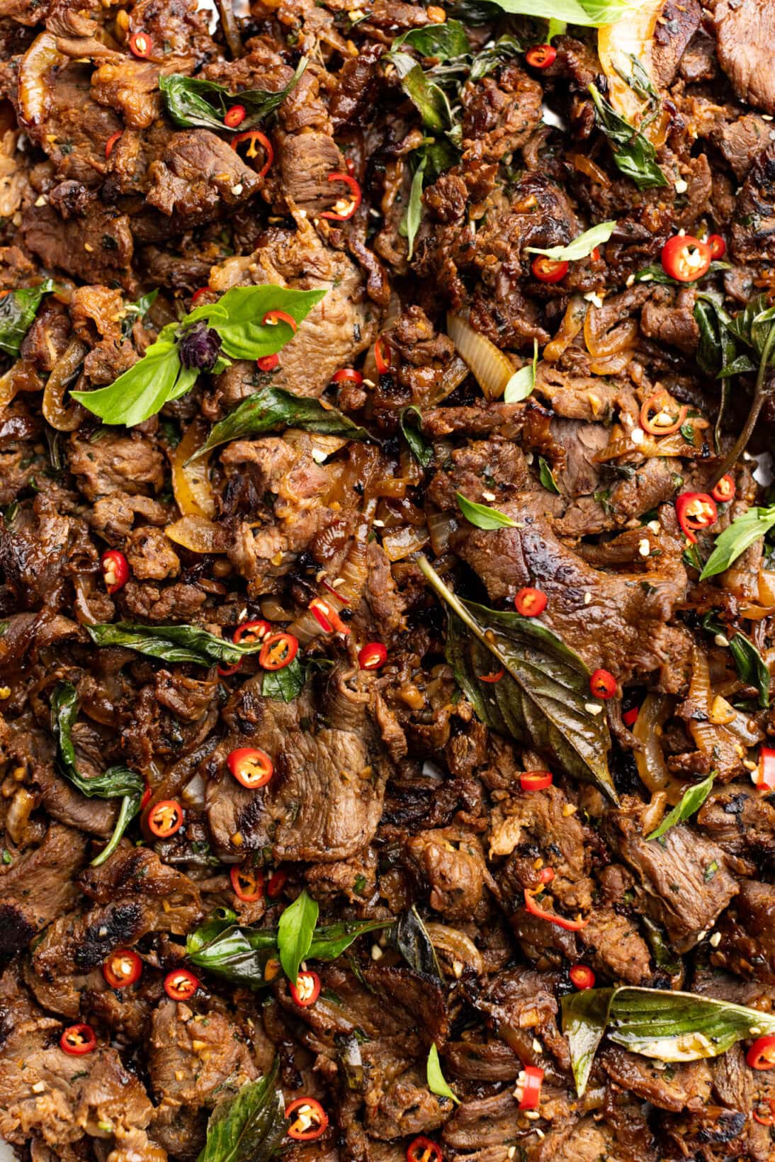up close Thai basil beef topped with extra chilies and basil.