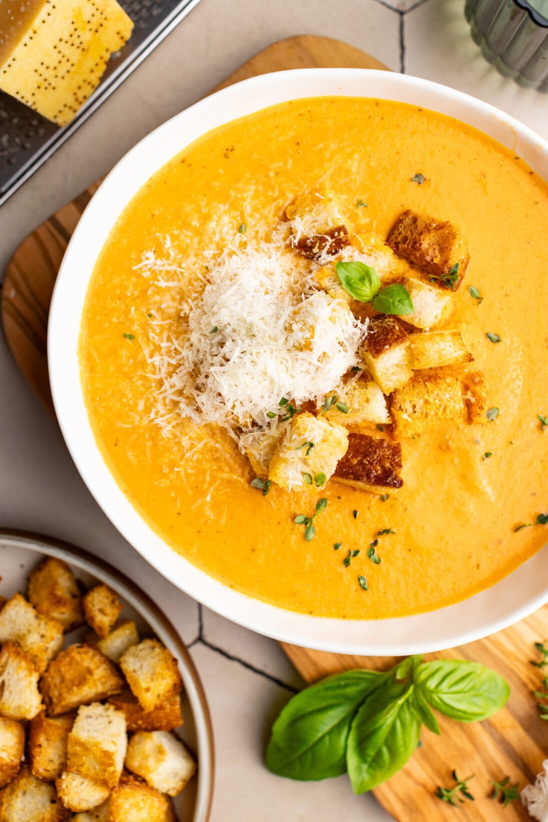 a bowl of creamy roasted tomato soup with cheesy parmesan croutons