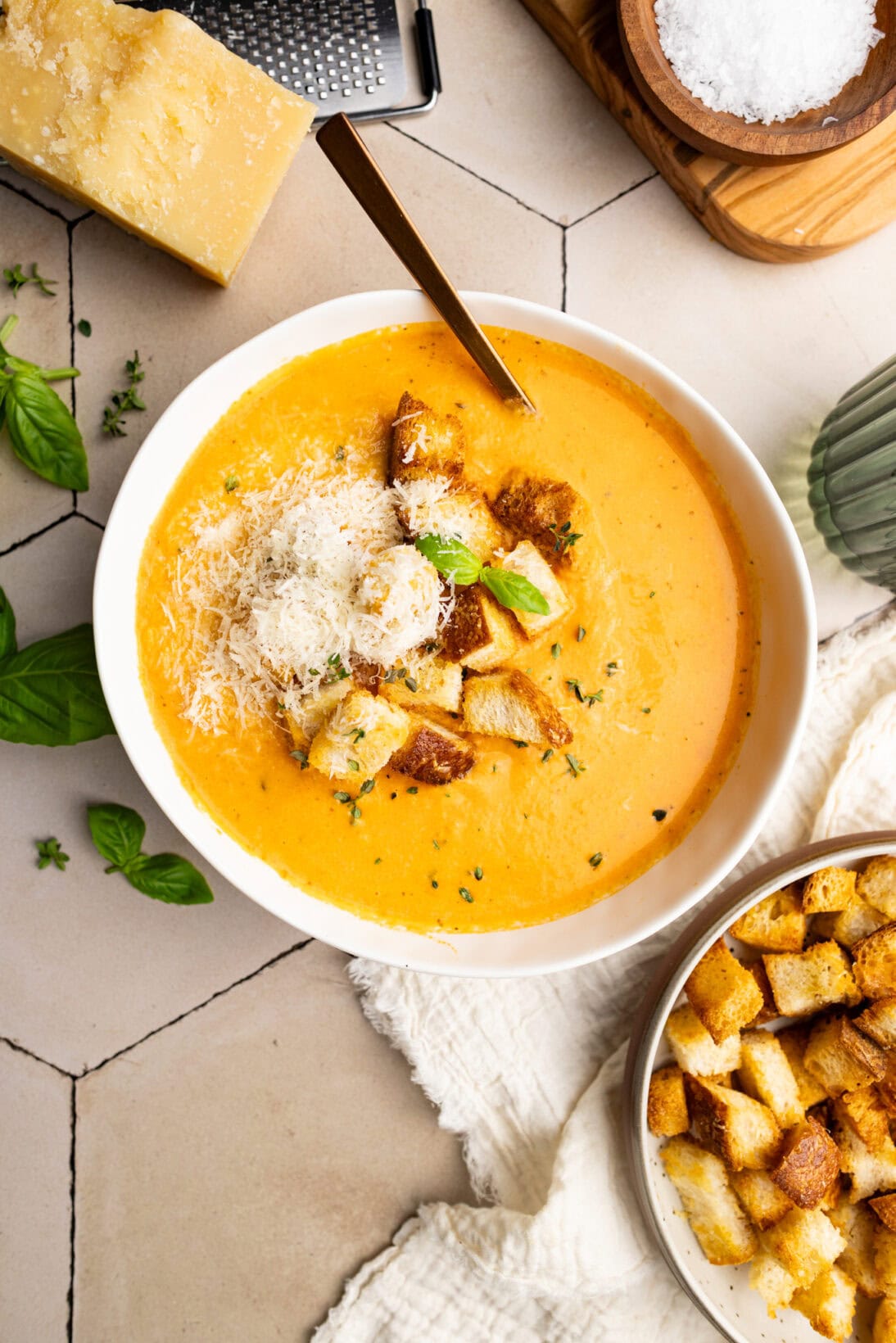 a bowl of creamy roasted tomato soup with cheesy parmesan croutons