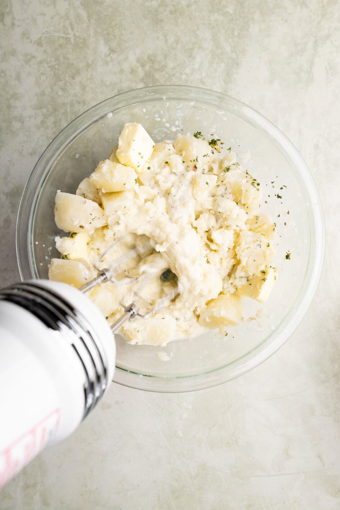 beating the garlic and herb mashed potatoes with a hand mixer. 