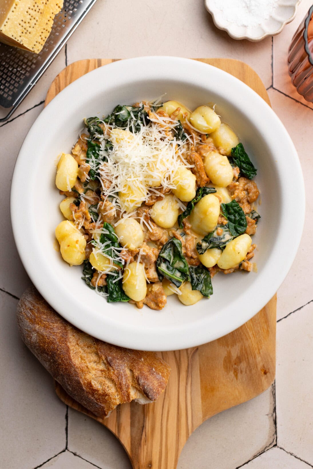 a bowl of creamy tuscan gnocchi topped with extra Parmesan