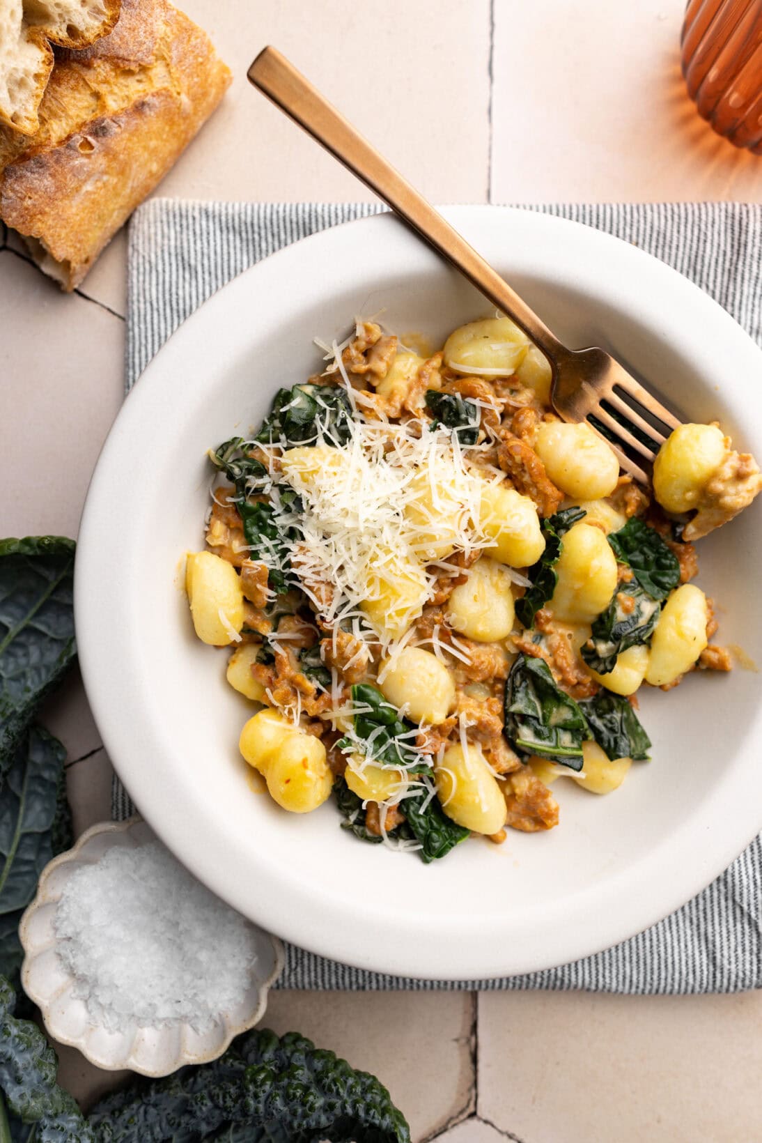 a bowl of creamy tuscan gnocchi topped with extra Parmesan
