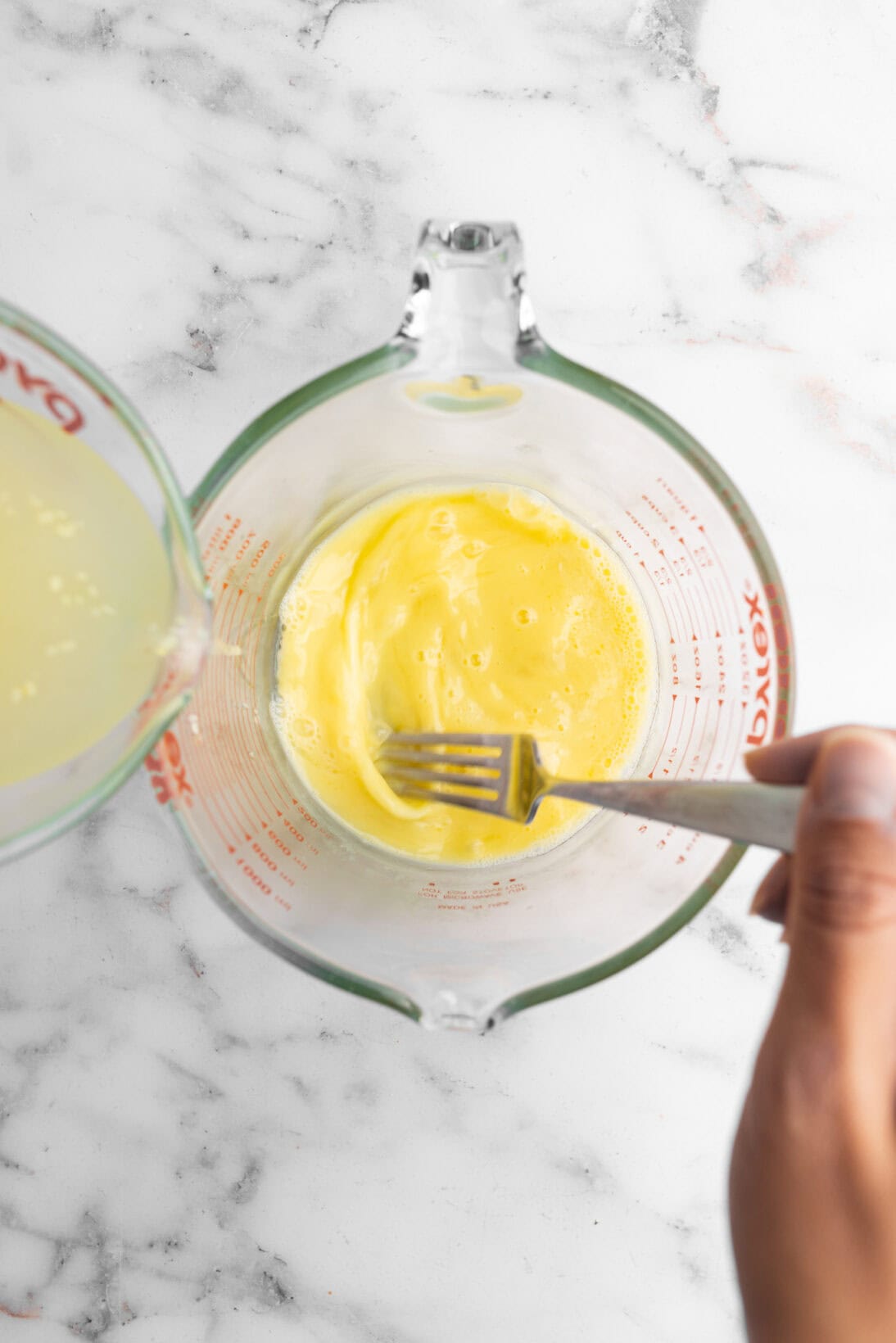 tempering the egg slowly by adding the chicken broth while mixing.