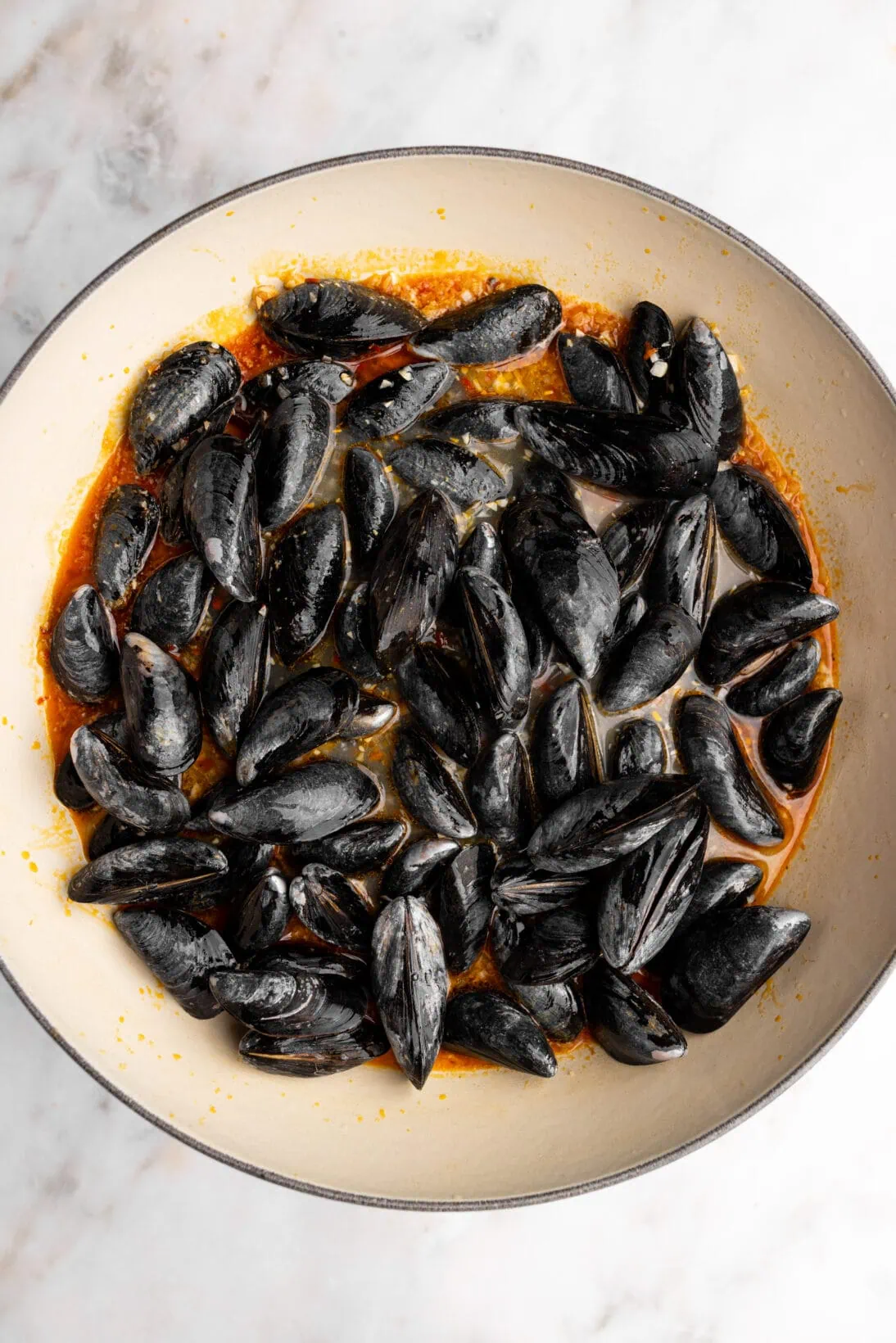 step by step: uncooked mussels tossed into the pan