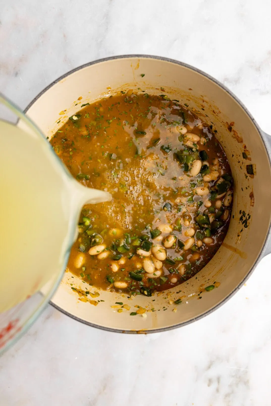 step by step: adding the broth to the pot.